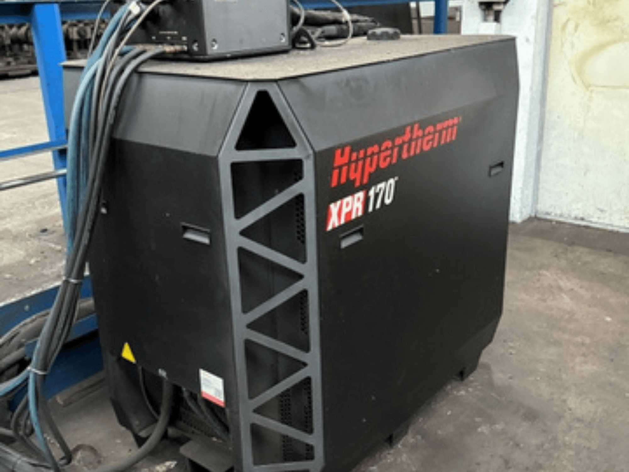 Cortador de plasma Hypertherm XPR170, visto de lado, com aberturas de resfriamento e vários cabos para operação.