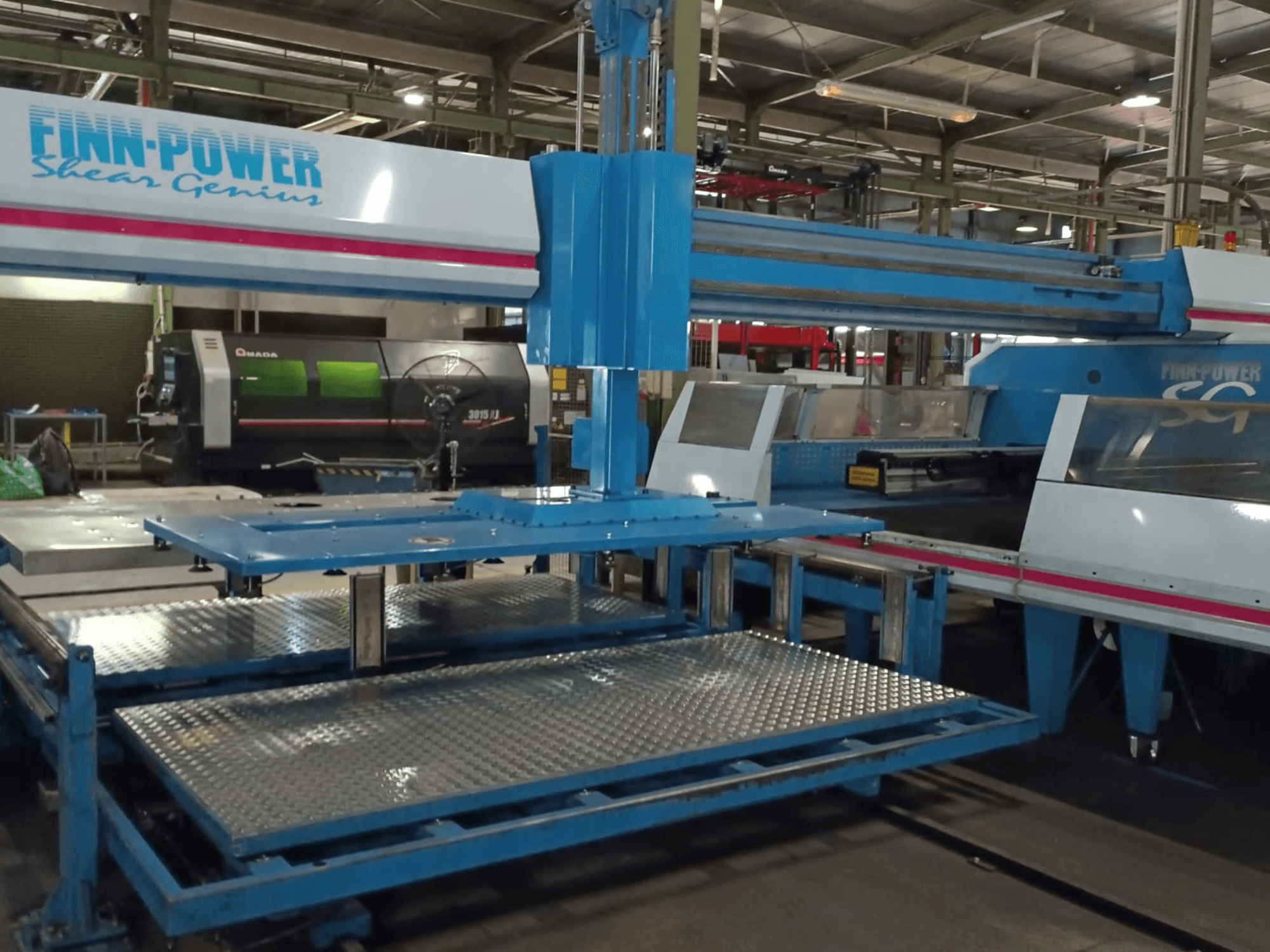 Máquina de perfuração CNC Finn-Power SG6 «Shear Genius» vista de frente, mostrando as mesas metálicas e as características estruturais.