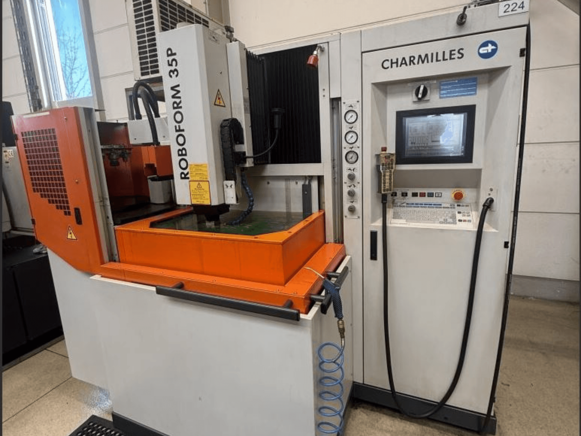 Máquina de EDM para confeção de matrizes ROBOFORM 35P da Charmilles, vista frontal, com painel de controlo, pórtico e depósito de fluido em funcionamento.