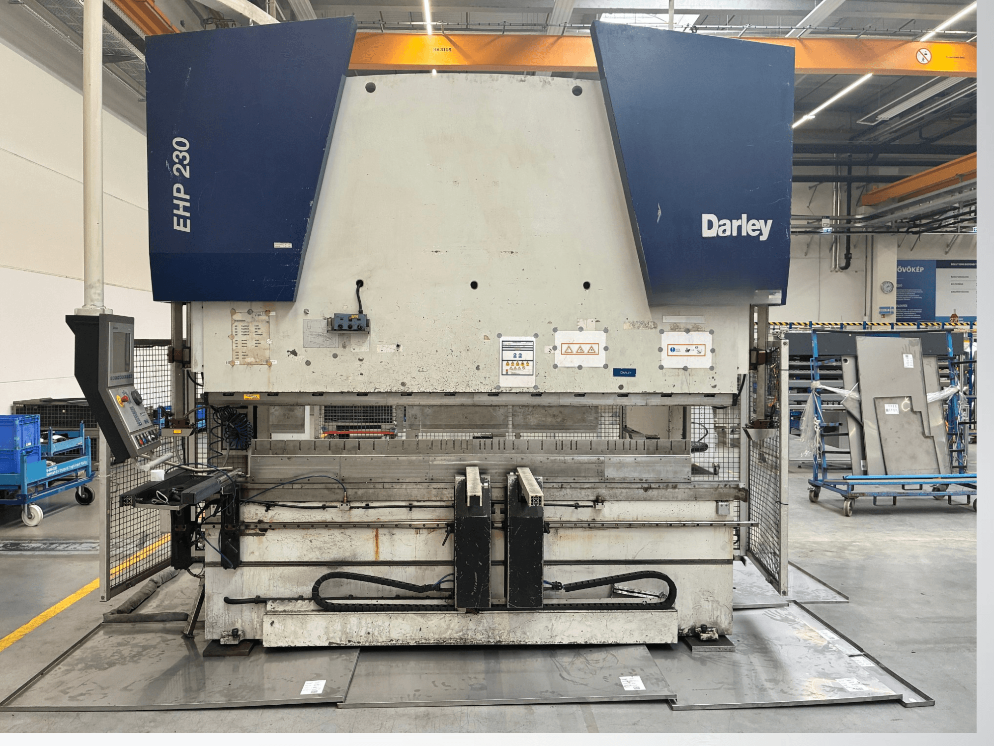Prensa hidráulica Darley EHP-LS 230.31/25, vista frontal, com painel de controlo e chapas metálicas próximas. Ideal para aplicações industriais.