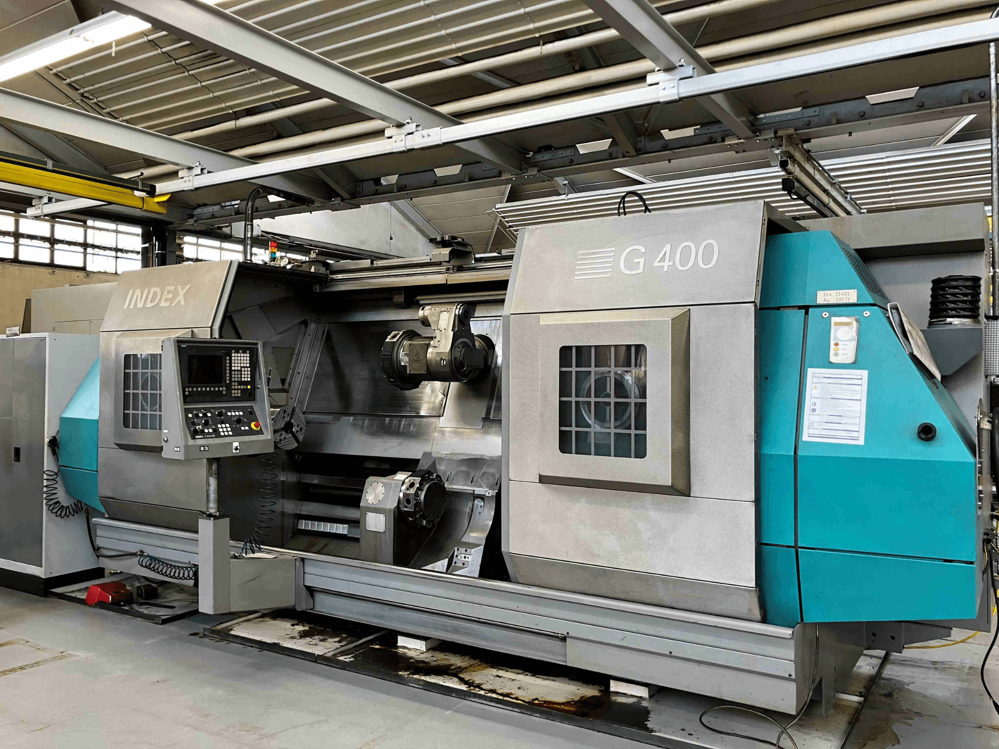 Torno CNC INDEX G400, vista frontal, com painel de controlo com visor numérico e duplo fuso para maquinação de precisão.