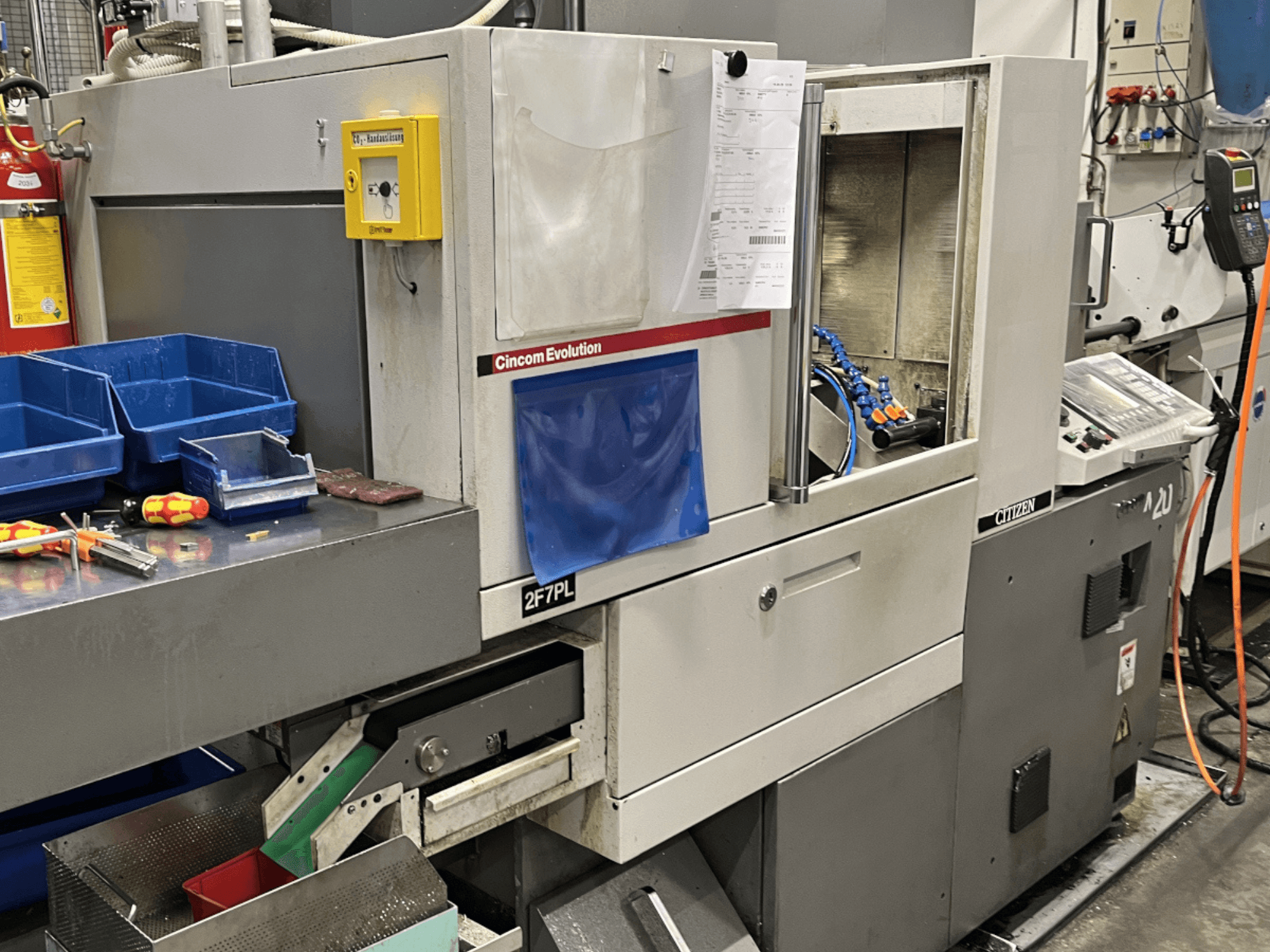 Centro de maquinação Cincom Evolution 2F7PL, vista frontal; possui controlos, caixas de ferramentas e um painel de operação detalhado.