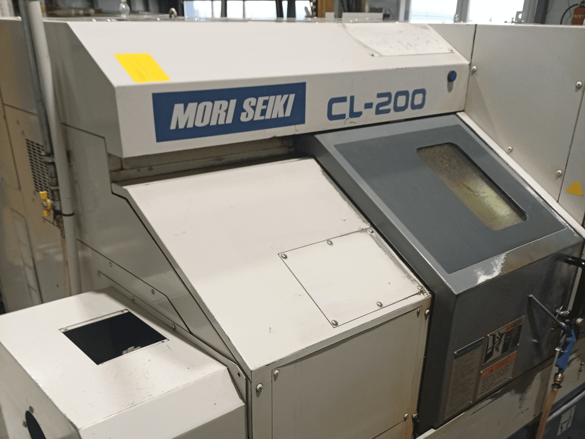 Torneiro horizontal DMG Mori Seiki CL-200B, vista frontal mostrando o painel de controlo e detalhes da janela de refrigeração.