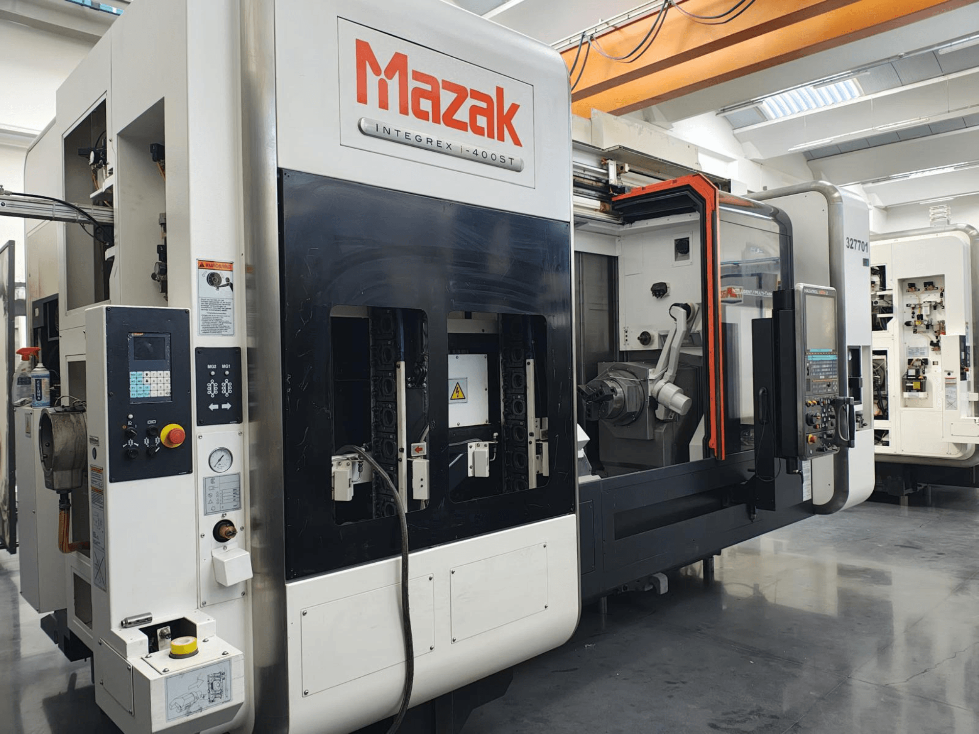Mazak Integrex 400ST, vista frontal; máquina CNC com painel de controlo, fusos e braço robótico visíveis numa oficina.