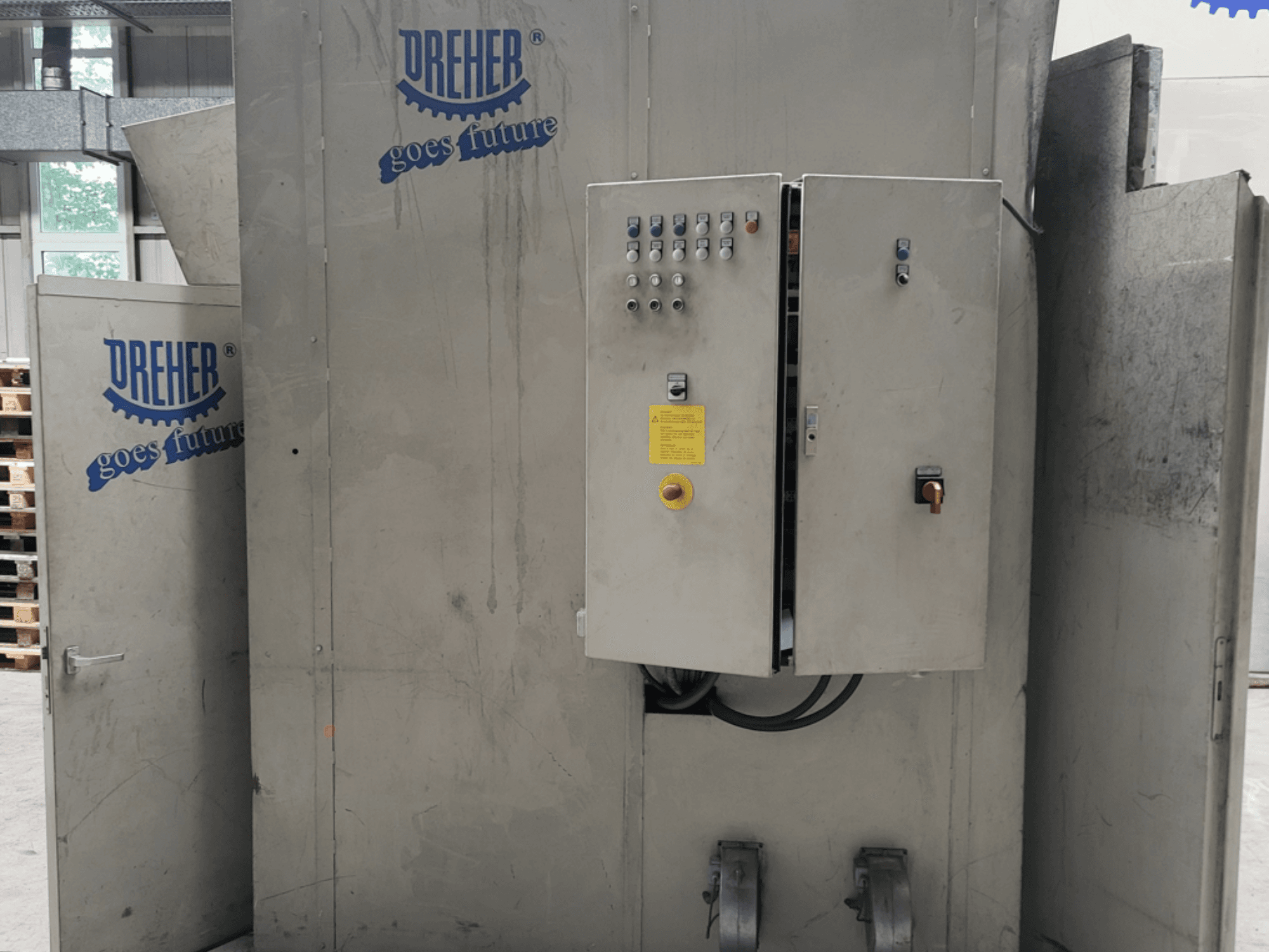 Máquina de transformação de plástico DREHER S 42/65 GFS-15 GR, vista frontal que mostra o painel de controlo e a marca, num ambiente industrial.