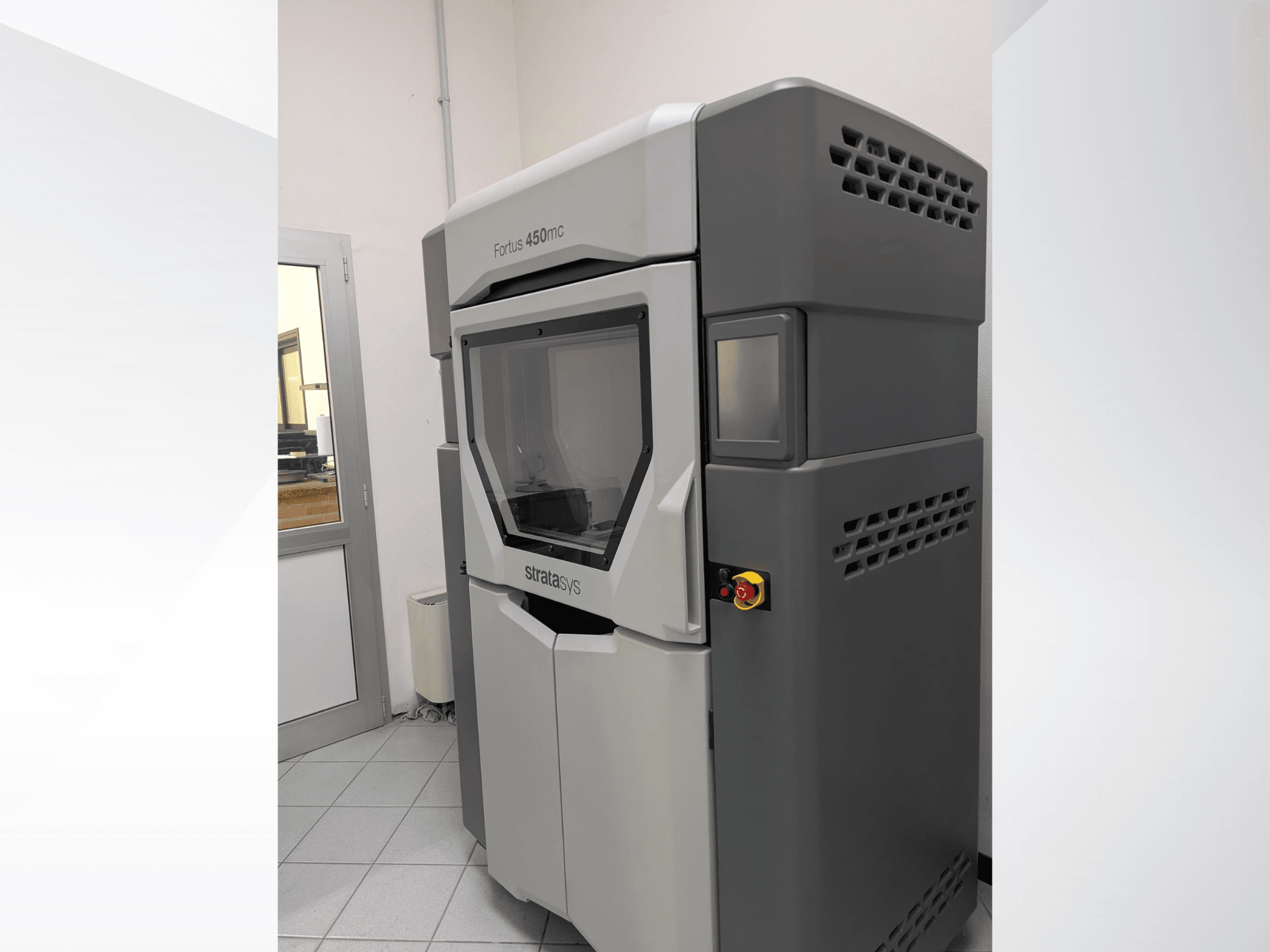 Impressora 3D de plástico Stratasys FORTUS 450mc numa vista lateral, mostrando um design elegante e um painel de controlo.