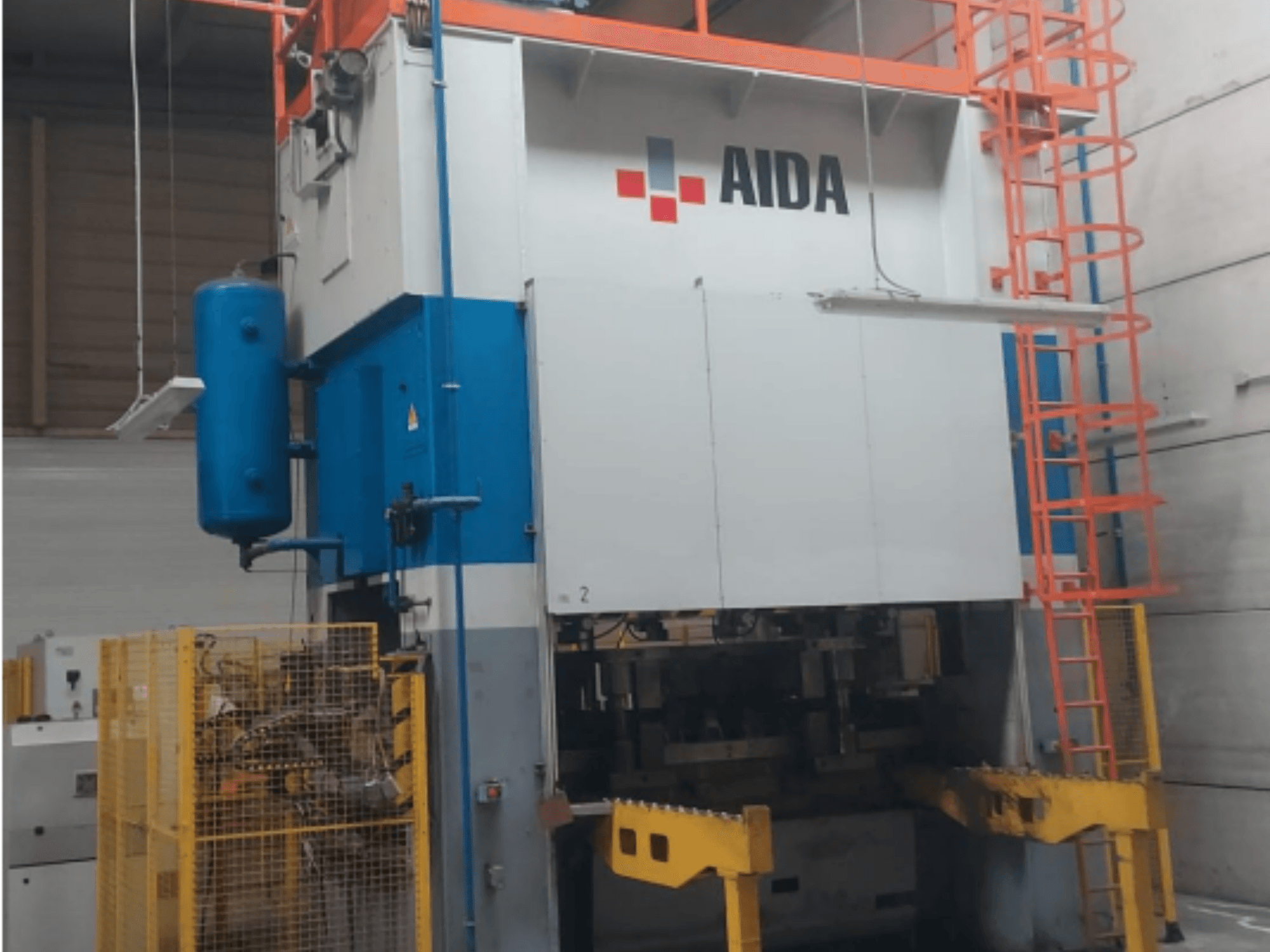 Prensa de estamparia mecânica AIDA 315/2MR/LD/TE 3, vista frontal com corpo azul e branco, base amarela e gaiola de segurança.