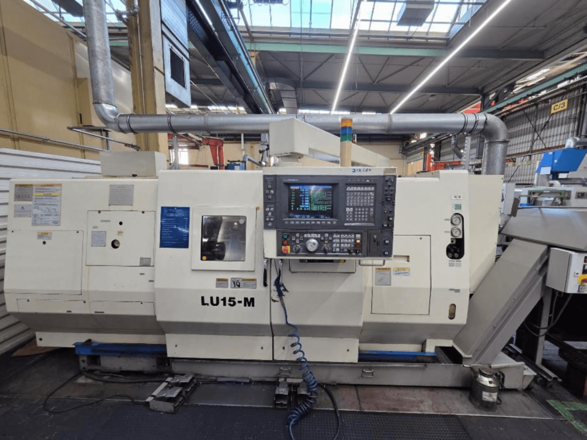 Okuma LU15 M-2SC 1000, virador horizontal, vista frontal mostrando o painel de controlo e as caraterísticas da máquina numa oficina.