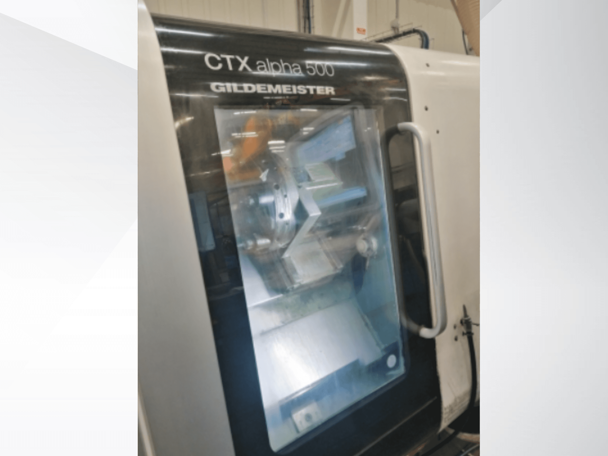 Máquina CNC CTX alpha 500 Gildemeister, vista frontal, mostrando o fuso e a área de maquinação através da porta de vidro.