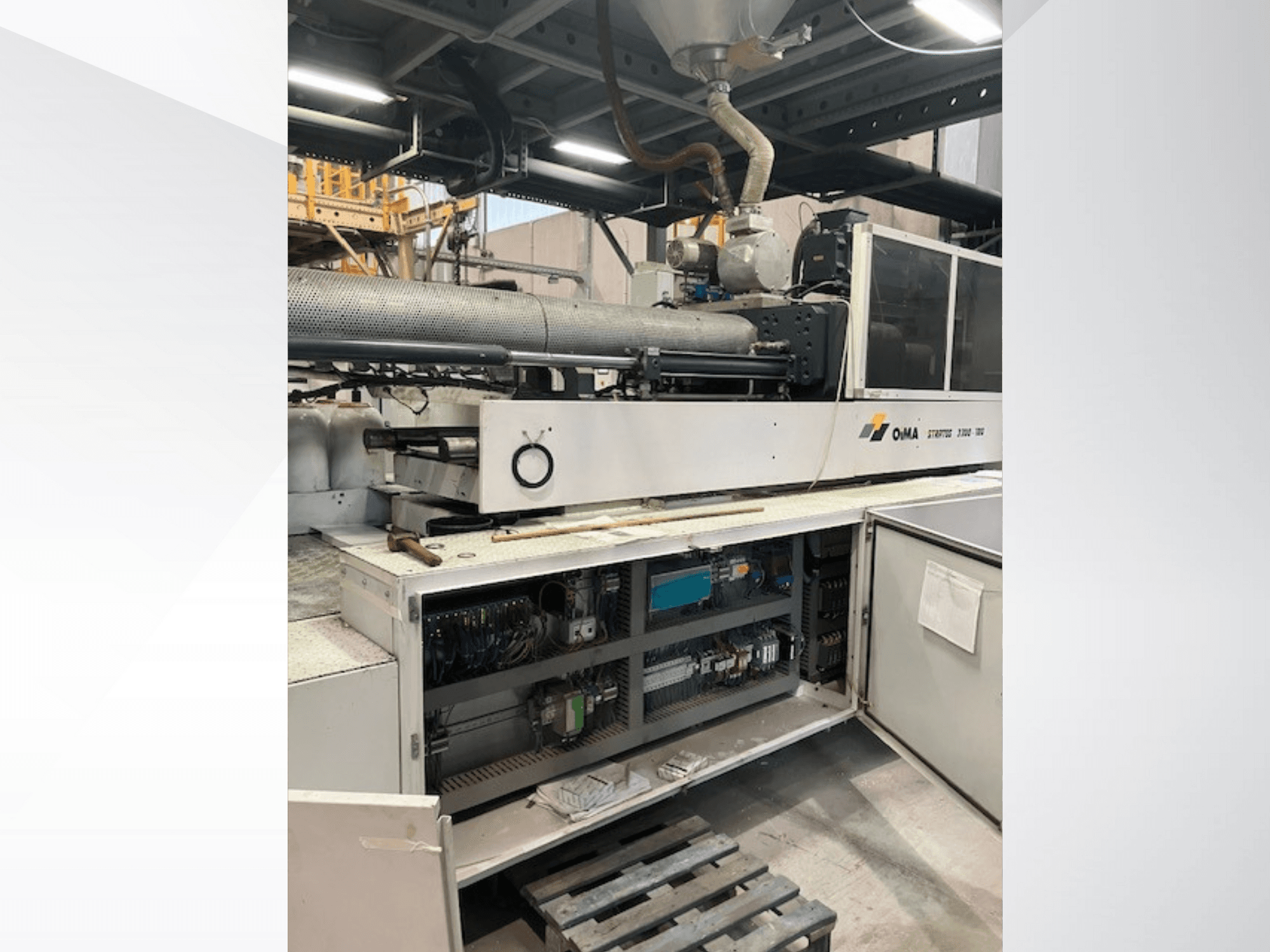 Vista frontal da Extrusora 3500 da OMA, mostrando peças operacionais, painel de controlo e detalhes da cablagem. Maquinaria pesada em ambiente industrial.