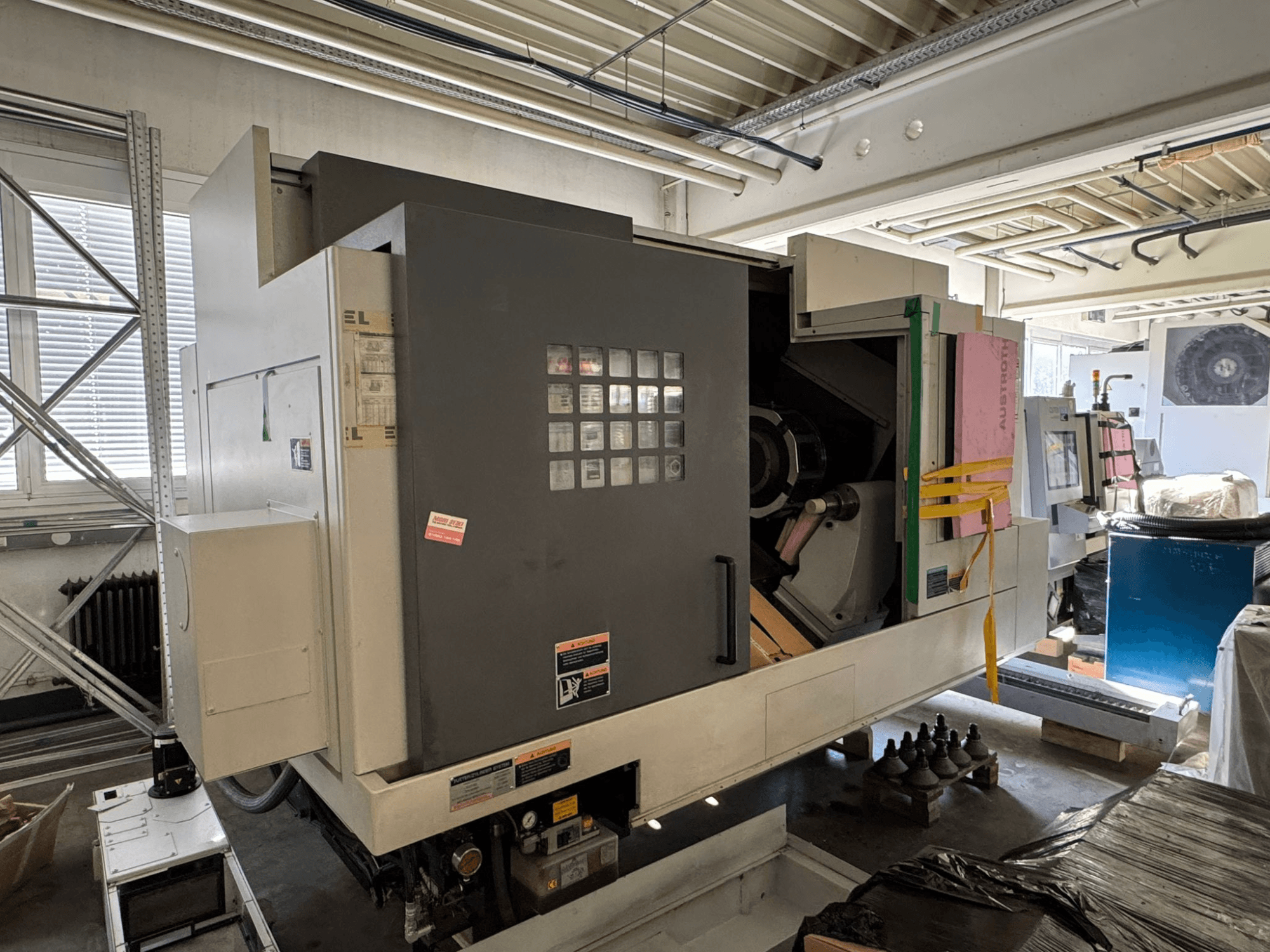 Torno horizontal MORI SEIKI NL 3000 MC/700, vista frontal com painel de controlo, área de armazenamento e cobertura protetora.