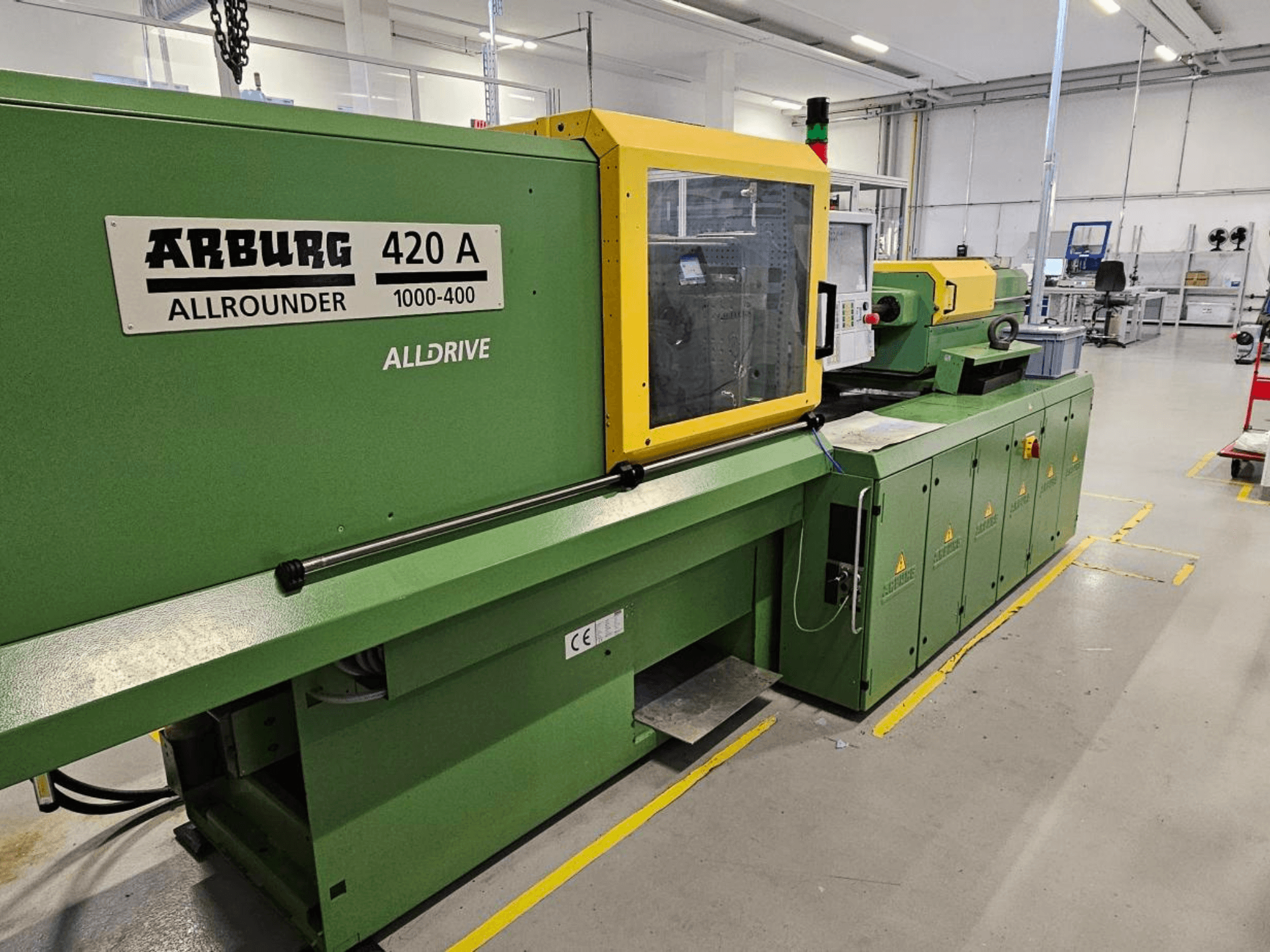 ARBURG 420 A Allrounder 1000-400, vista frontal; máquina verde com painel amarelo, ecrã tátil e dispositivos de segurança.