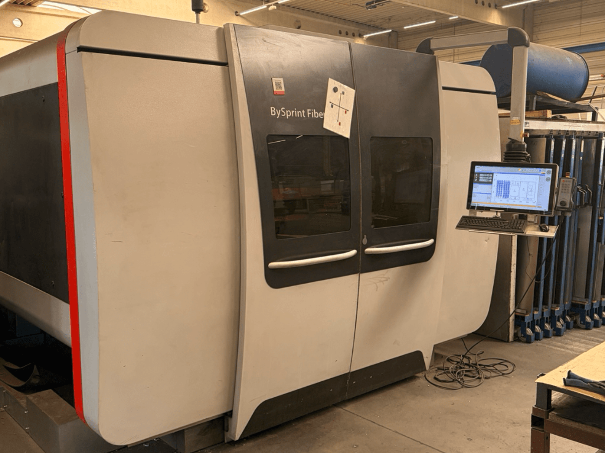 Bystronic BySprint Fiber 3015, vista frontal da máquina de corte a laser de fibra com painel de controlo tátil e configuração industrial.