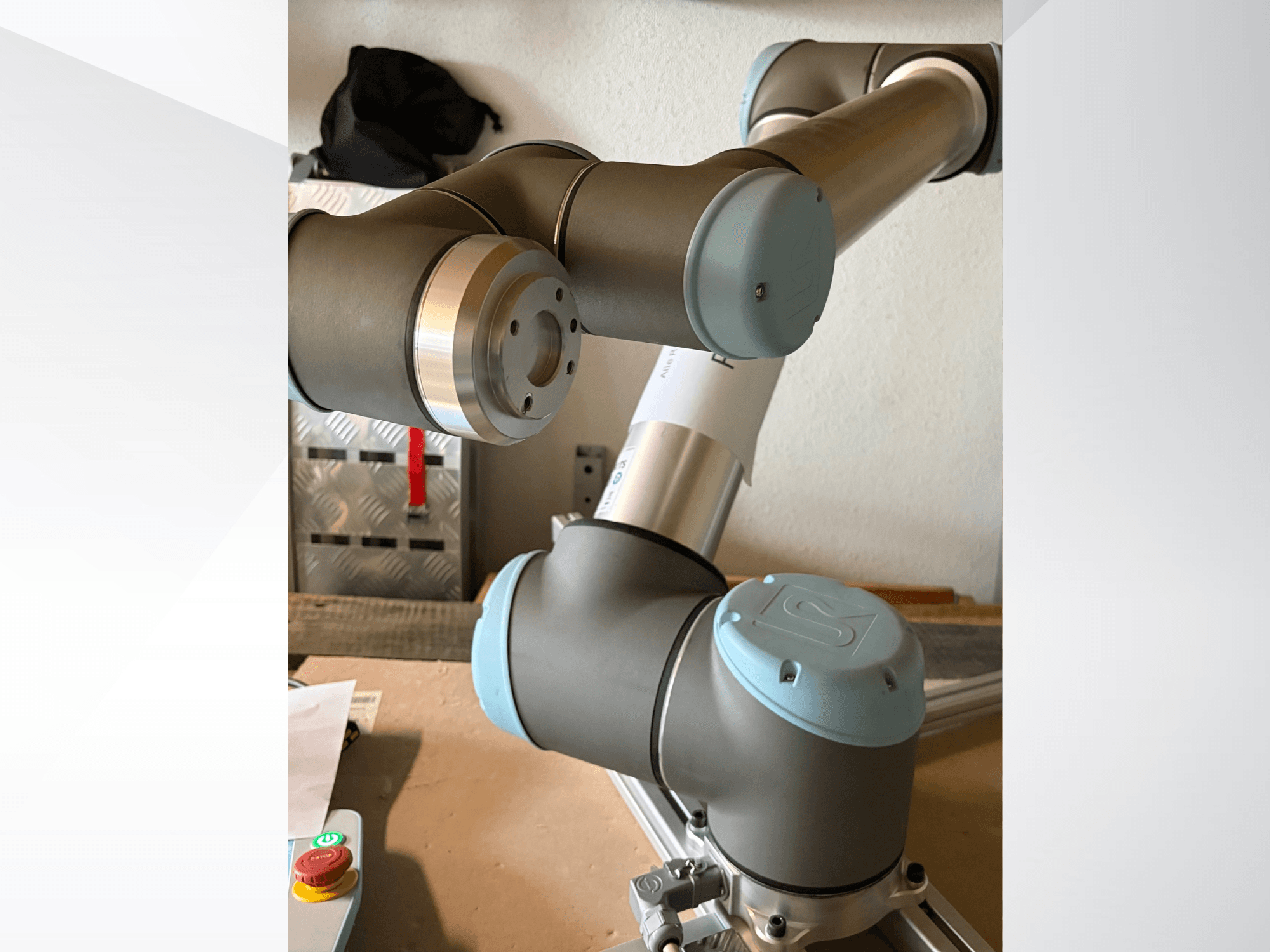 Vista lateral em grande plano de um braço robótico Universal Robots UR10, destacando as articulações e os elementos de design em cinzento-azul.