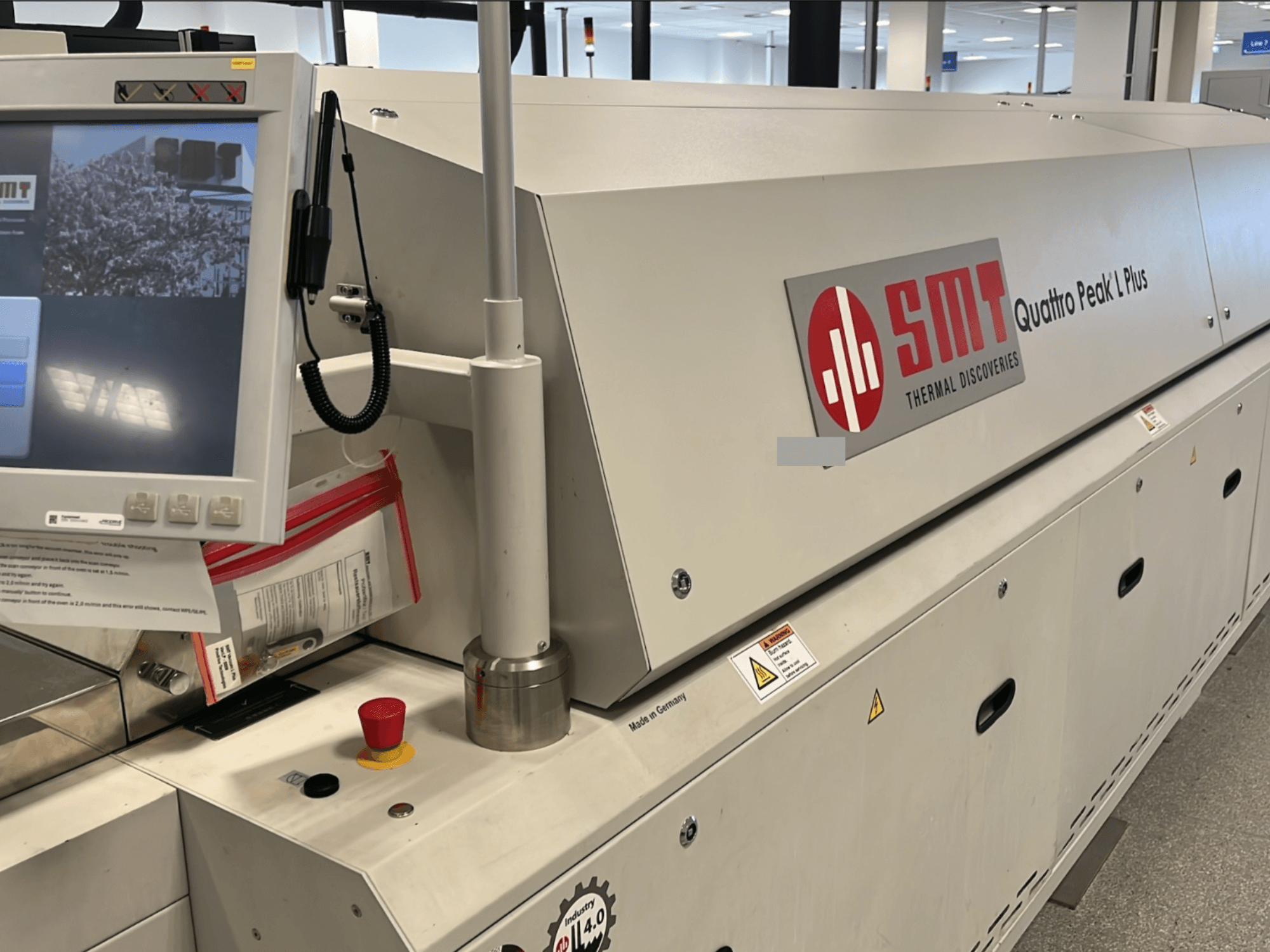 Máquina-ferramenta SMT Quattro Peak L Plus, vista frontal, com painel de controlo, botões de segurança e marca claramente visíveis.