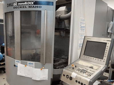 DMU 60 monoBLOCK de Deckel Maho, vista frontal de uma fresadora CNC com um painel de controlo e desenhos técnicos anexados.