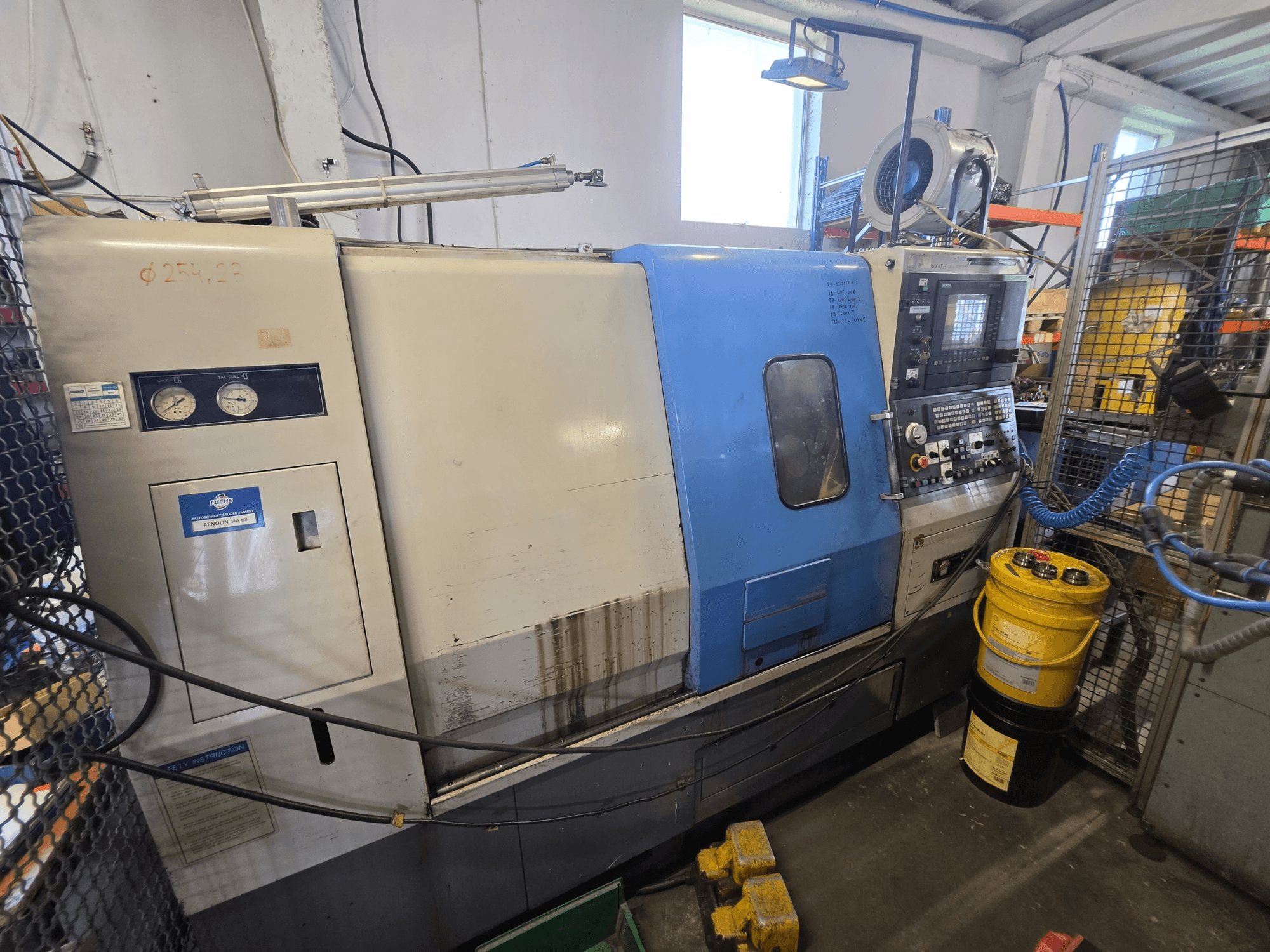 Torno horizontal Hyundai HIT-200C, vista frontal, com o painel de controlo, os indicadores e as instruções de segurança visíveis.