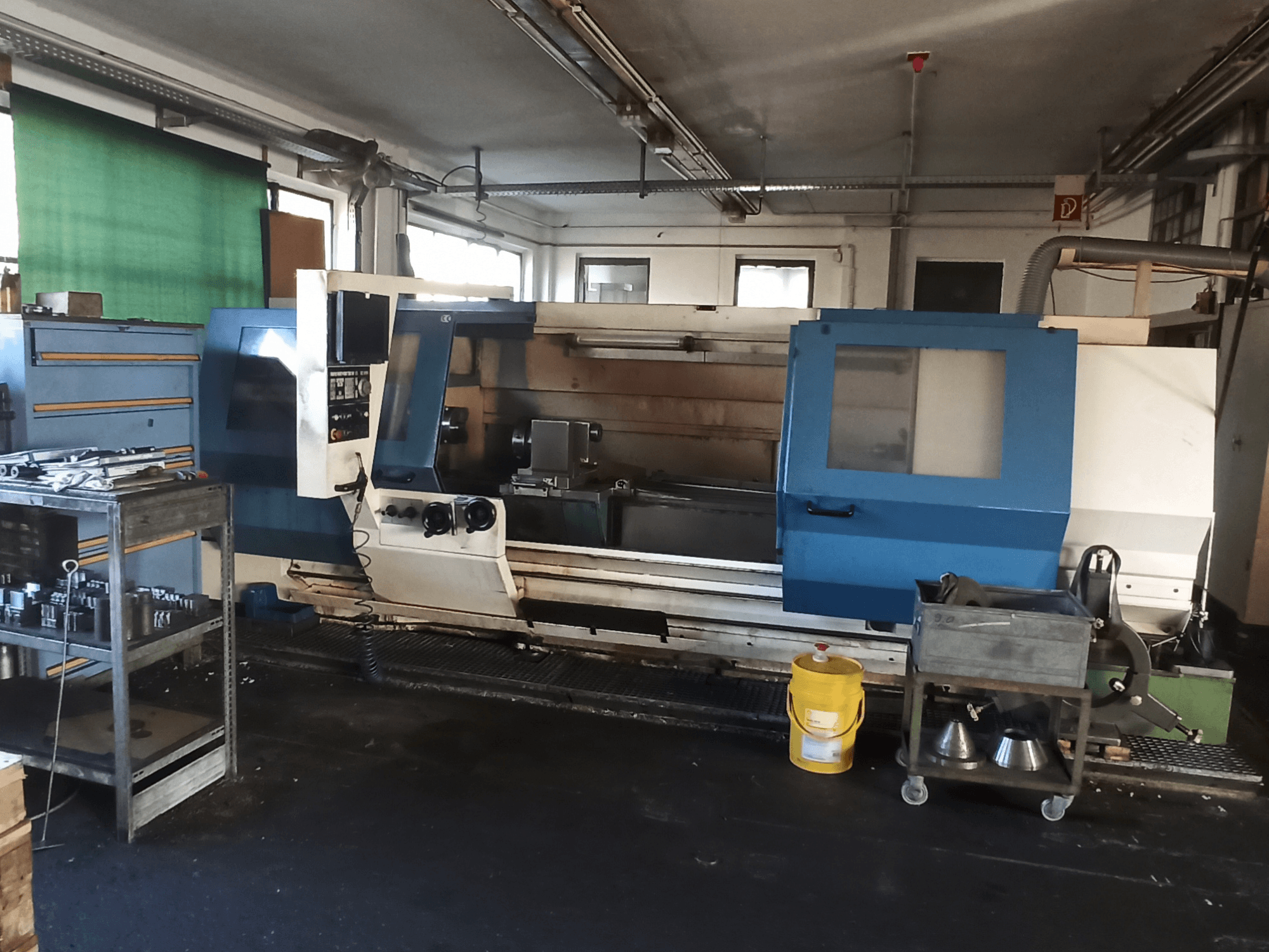 Torno horizontal BOEHRINGER DUC 560/2000 numa oficina, com vista lateral do painel de controlo e da área de trabalho.