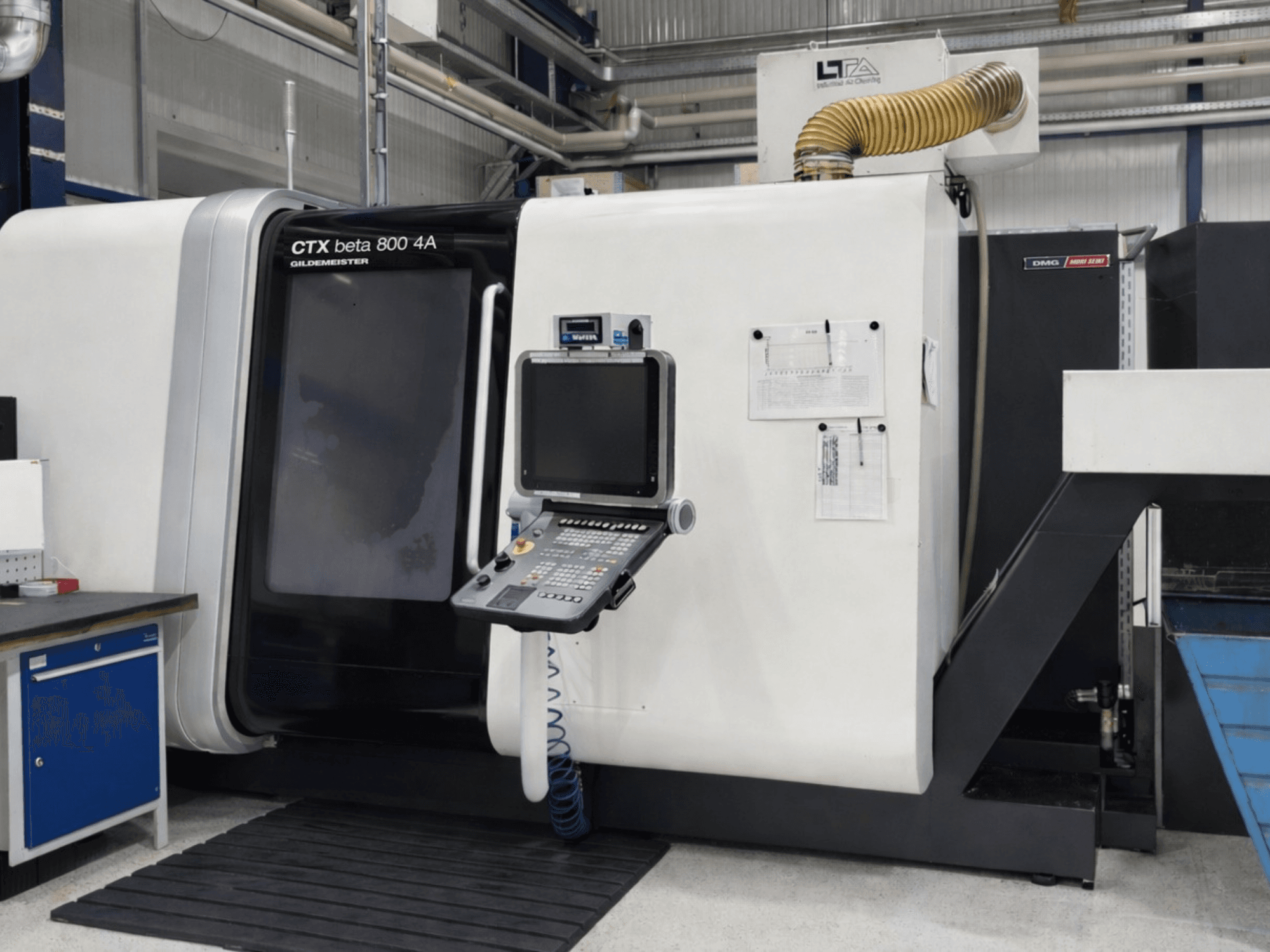 Torno multifuso DMG CTX beta 800 4A, vista frontal, com o painel de controlo e a documentação operacional visíveis.