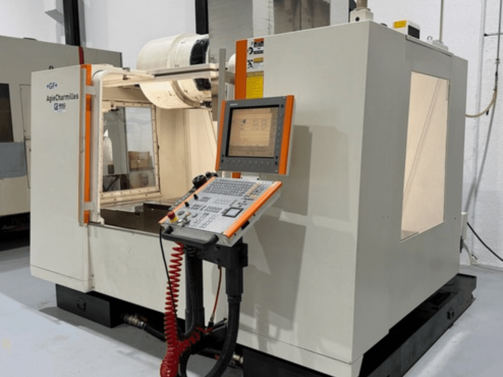 Fresadora GF AgieCharmilles MIKRON em vista lateral, com um painel de controlo com botões e um ecrã de visualização.