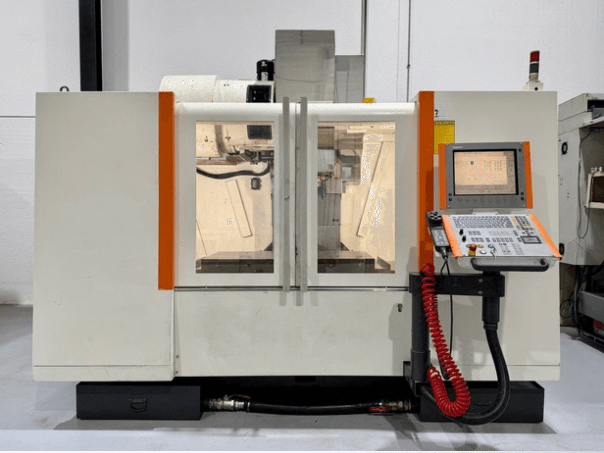 Máquina CNC com detalhes em laranja, vista frontal. Inclui painel de controlo e funcionamento interior visível.