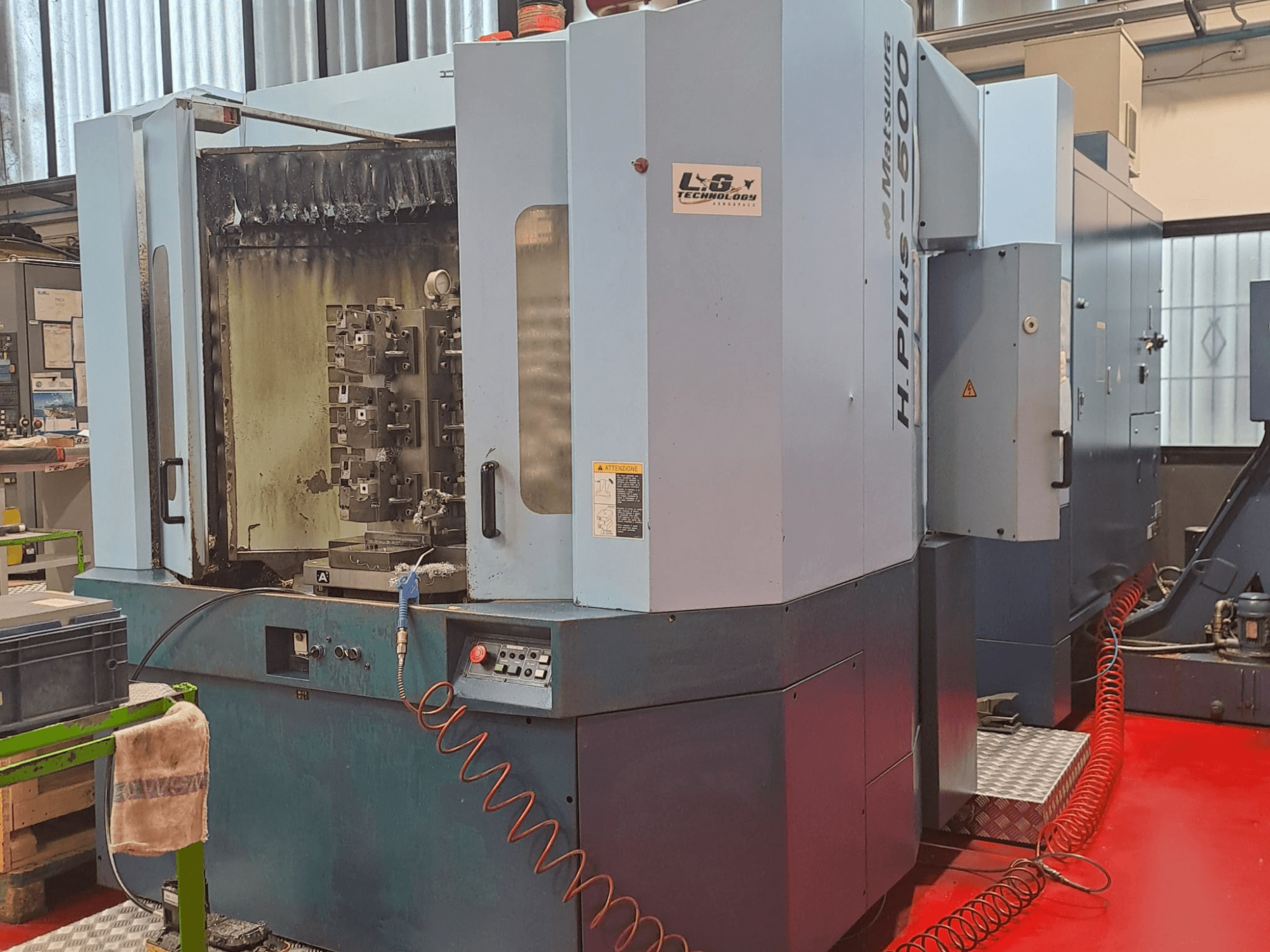 Centro de maquinação horizontal Matsuura H.PLUS-500, vista lateral, mostrando os controlos e o fuso com sinais de desgaste visíveis.