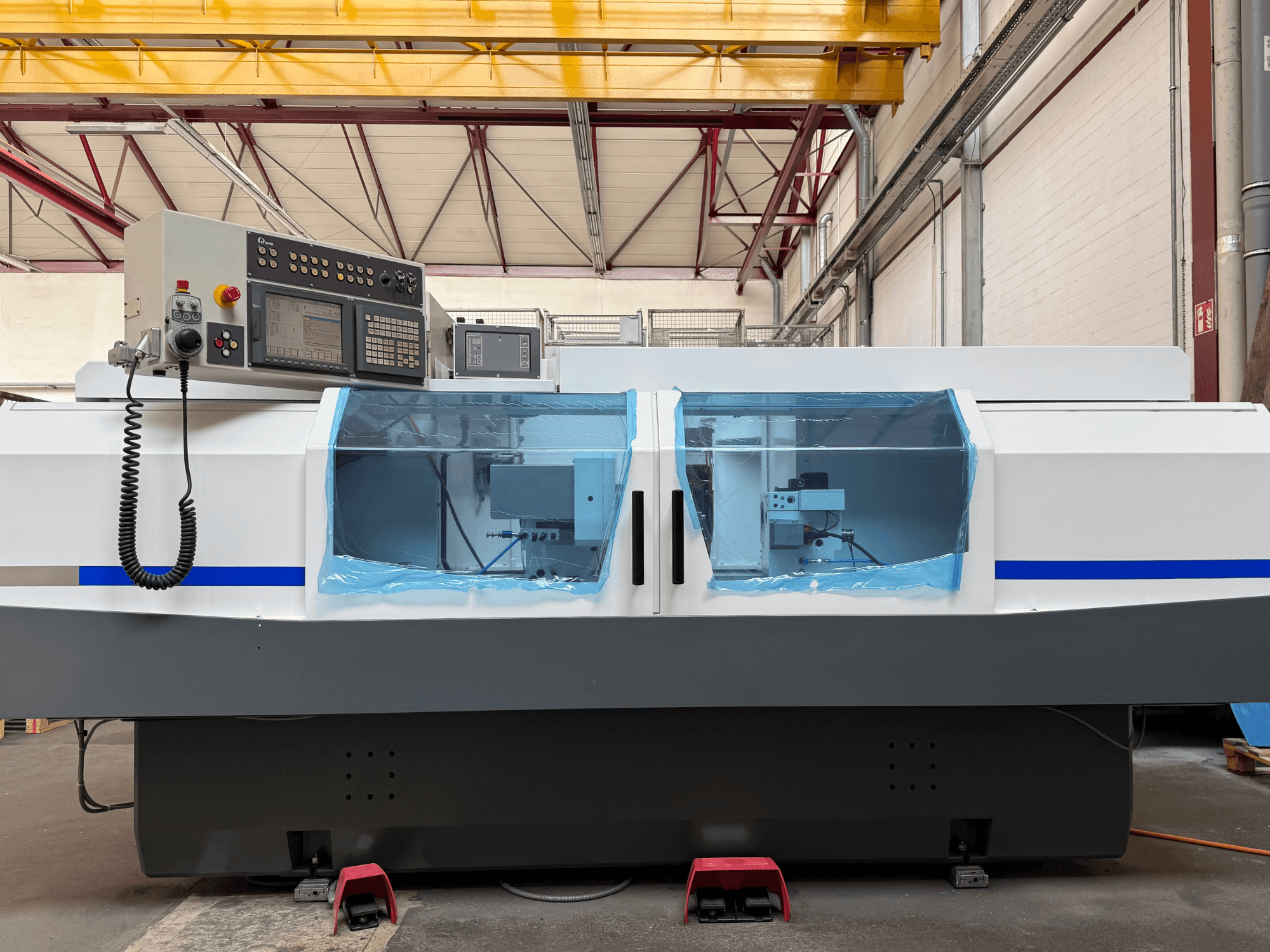 Retificadora cilíndrica STUDER S33 CNC vista de lado, com painel de controlo e proteções de segurança transparentes.