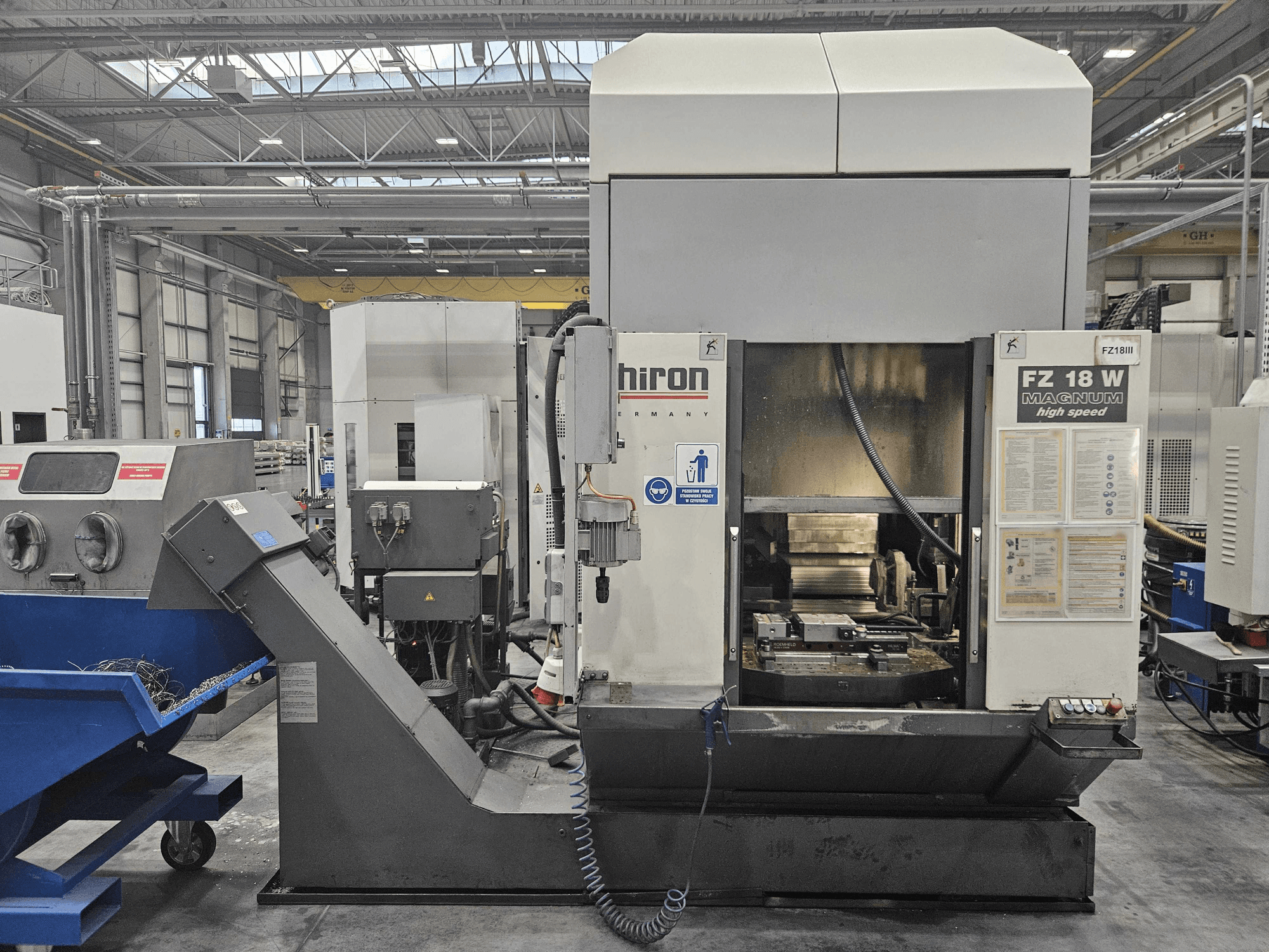 Máquina Hiron FZ 18 W Magnum, vista frontal, mostrando o painel de controlo, o fuso e a calha de eliminação de resíduos anexa.