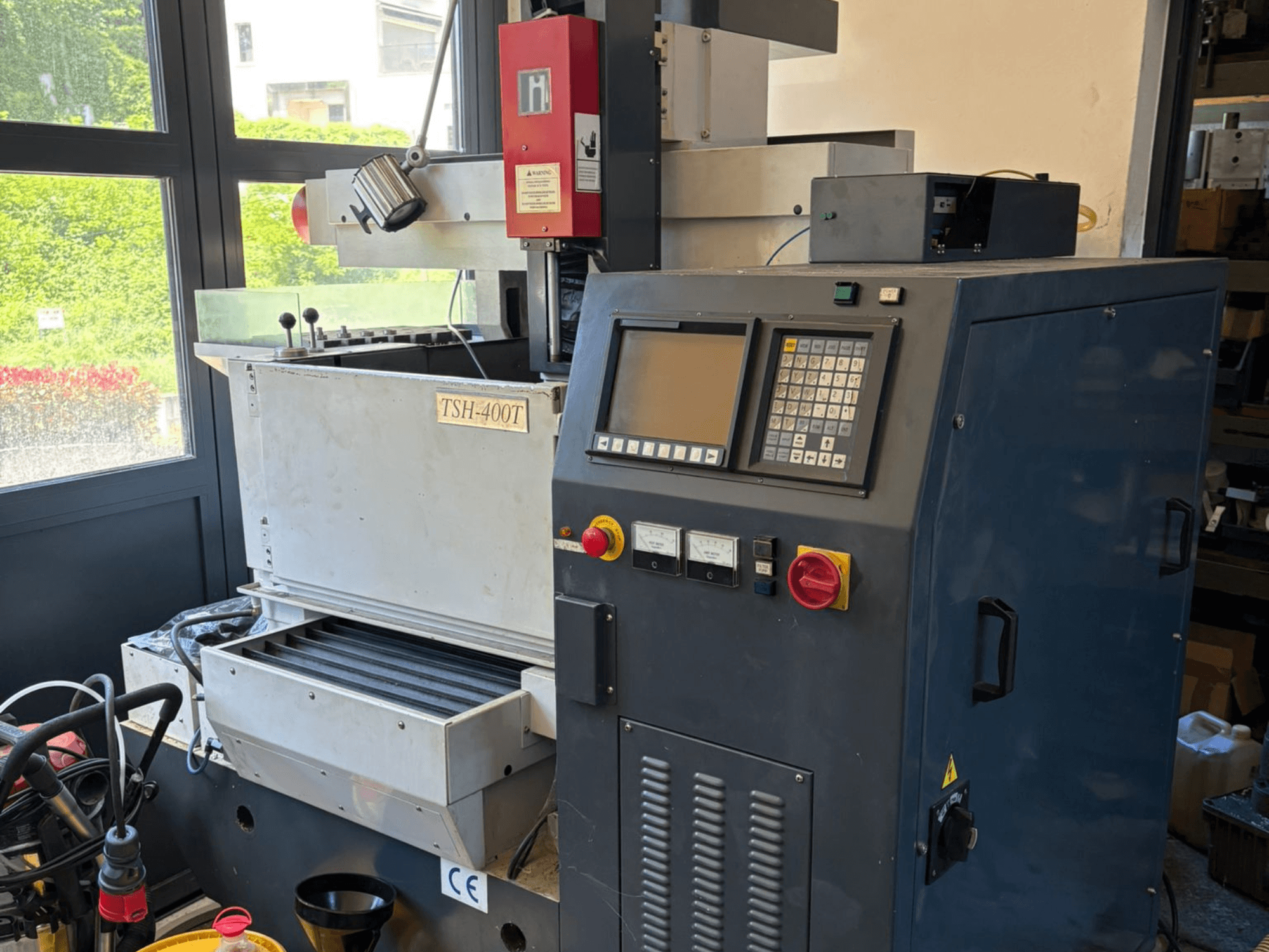 Vista superior da máquina EDM para confeção de matrizes TOPEDM TSH-400T, mostrando o painel de controlo e a área de trabalho. Adequada para tarefas de precisão.