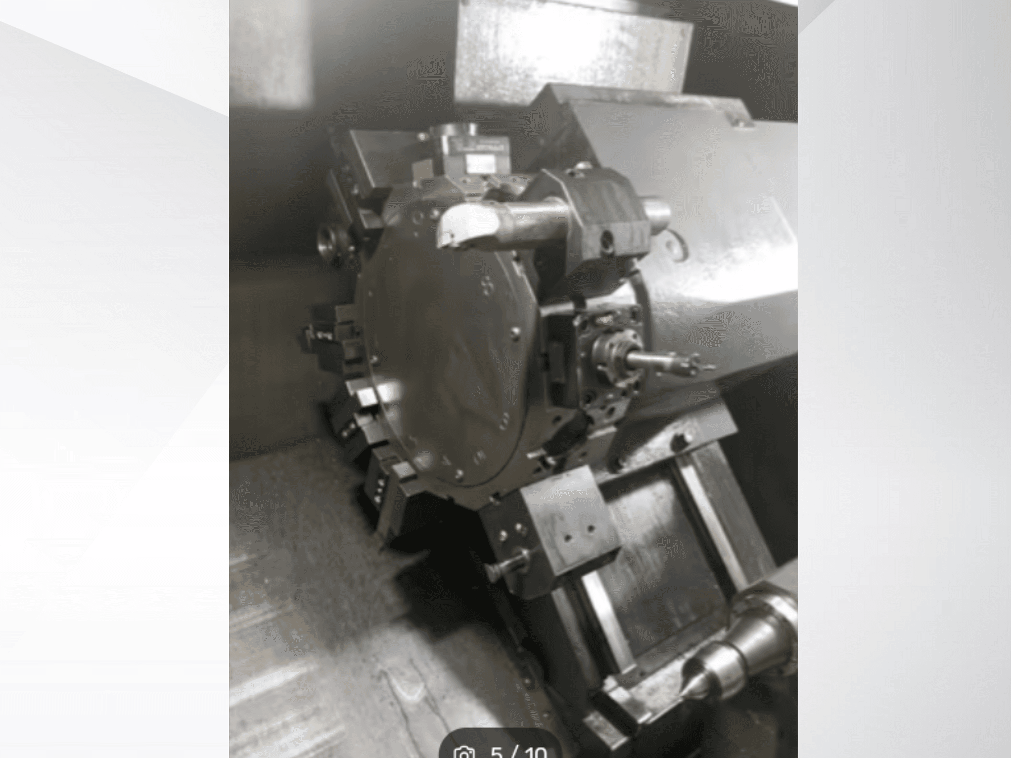 Grande plano de uma peça de máquina de precisão, mostrando engrenagens e componentes metálicos, visto de uma perspetiva angular. Não é visível qualquer marca.