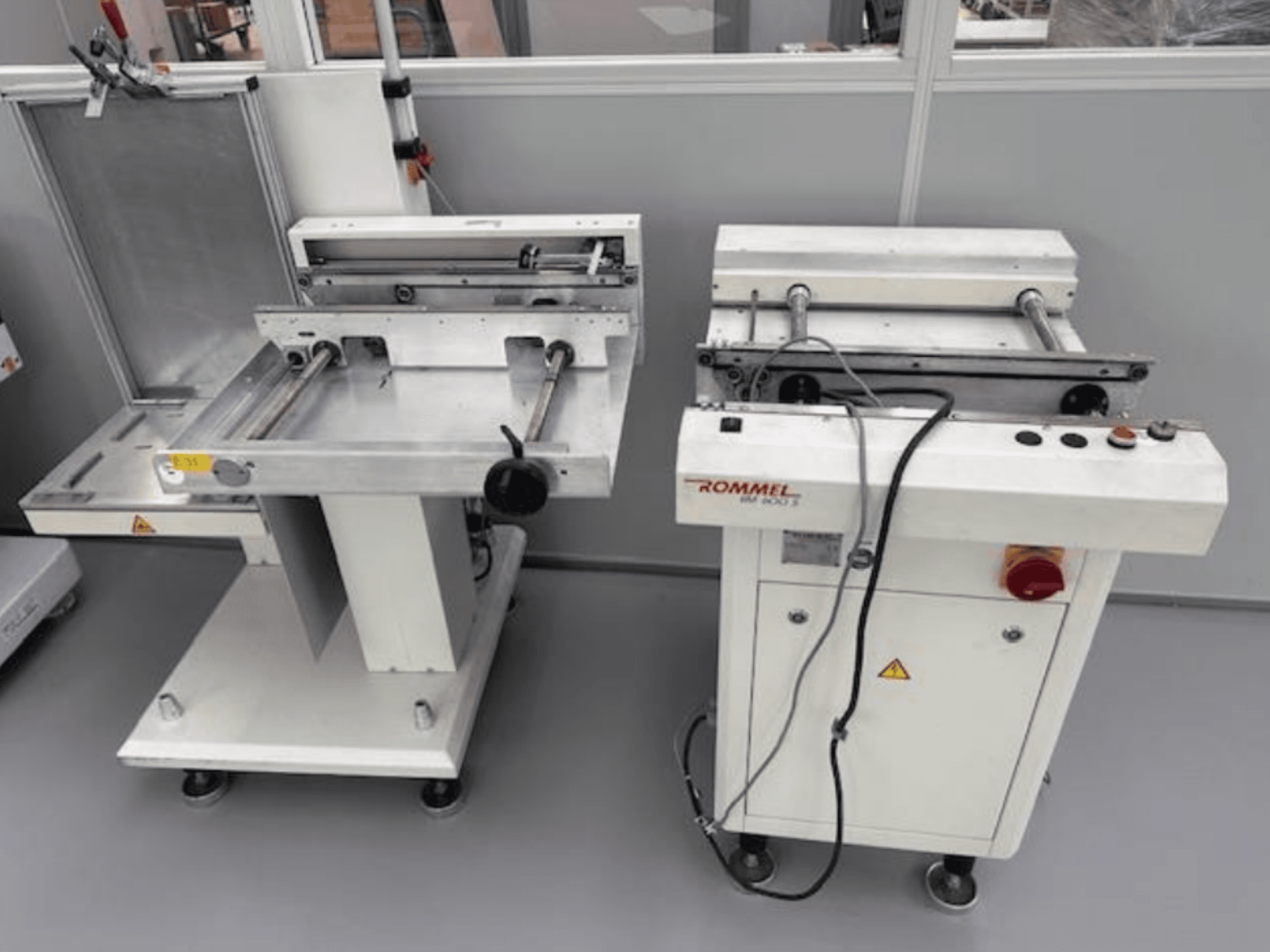 Máquina de etiquetagem Rommel HM 5033, vista frontal; possui painel de controlo, rolos e superfícies em aço inoxidável.