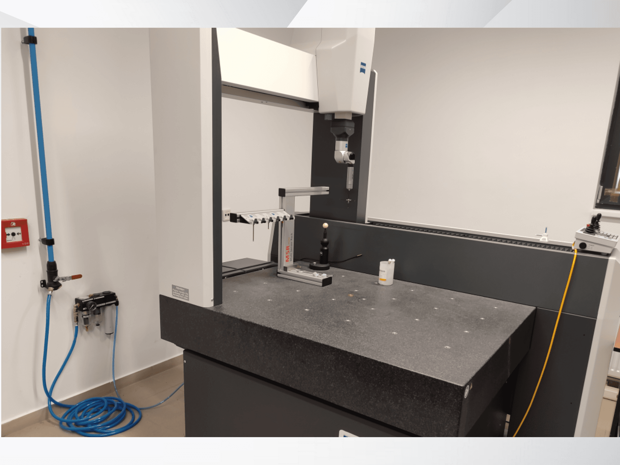 Dispositivo de medição MSR num laboratório, vista frontal mostrando uma mesa de granito, esfera de calibração e utilitários ligados.