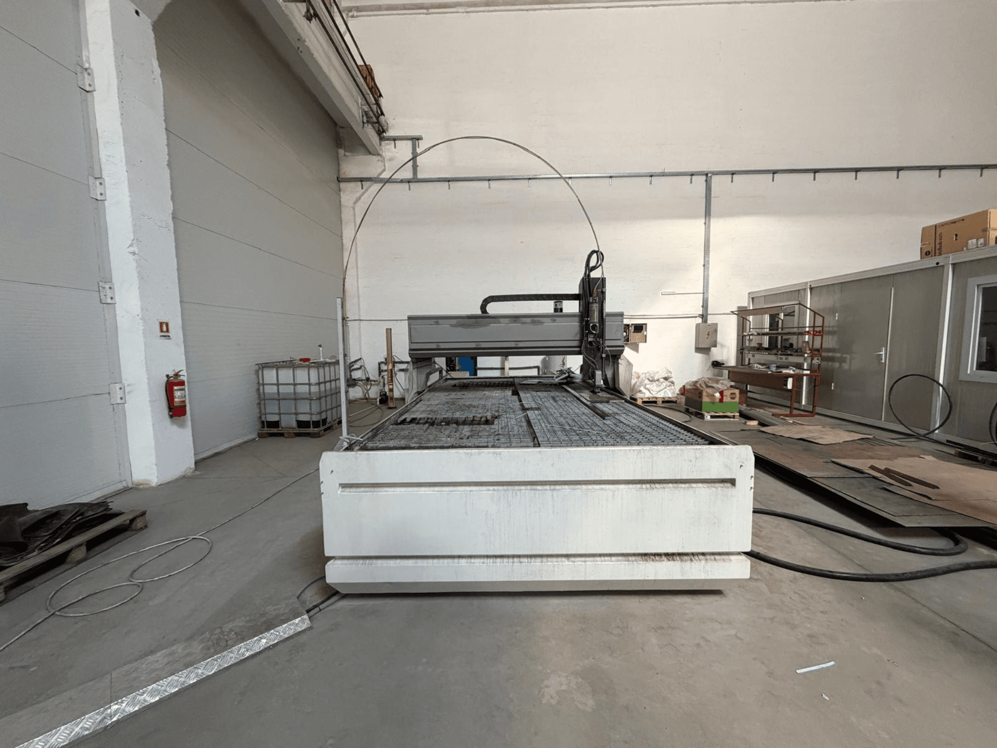 Máquina de corte por jato de água CMS SMARTLINE 2040, vista frontal, que destaca a sua ampla superfície plana e o ambiente industrial.