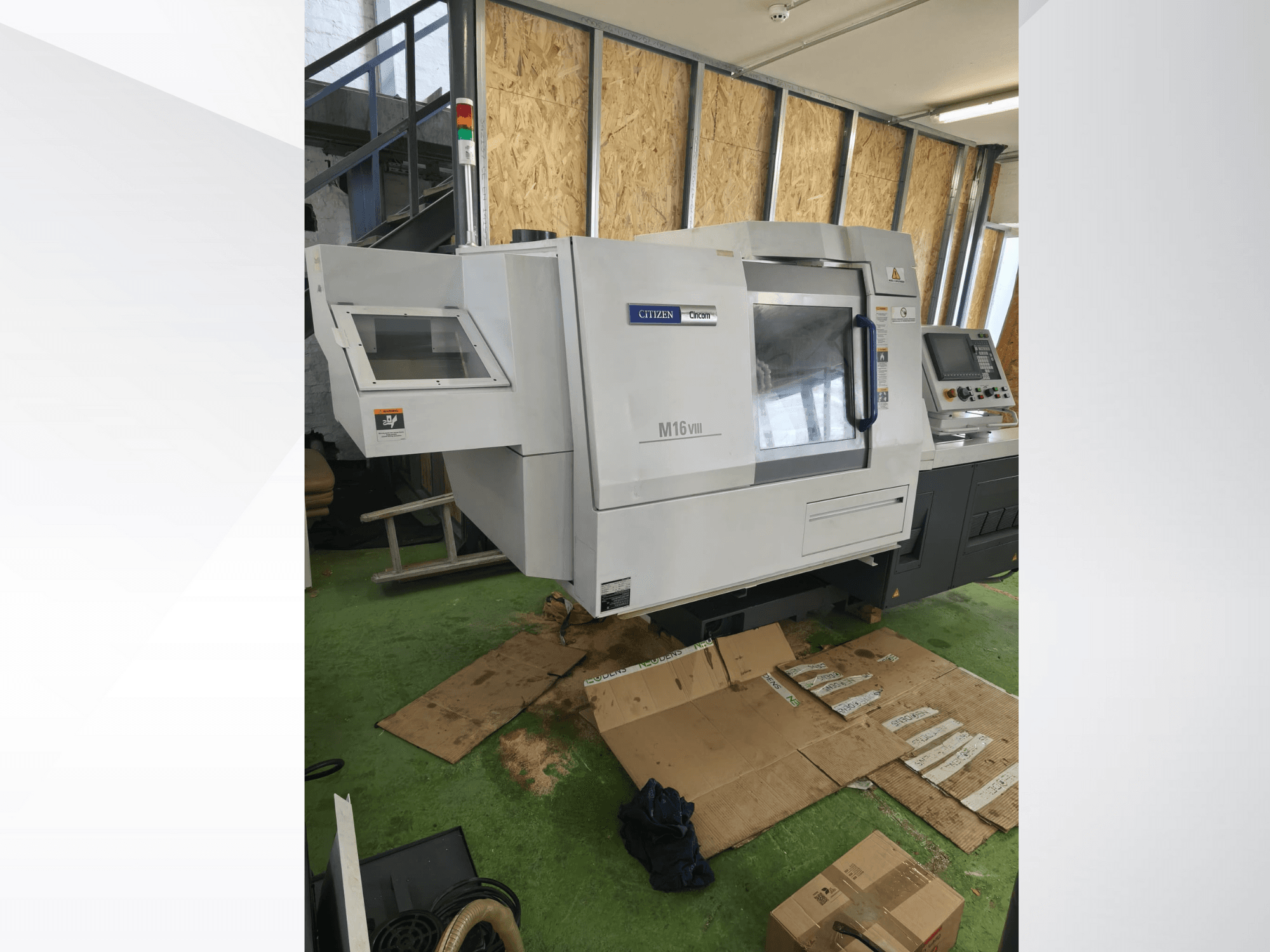 Torno CNC Citizen M16VIII em vista frontal, com painel de controlo e luzes de alerta de segurança, colocado sobre pavimento verde.