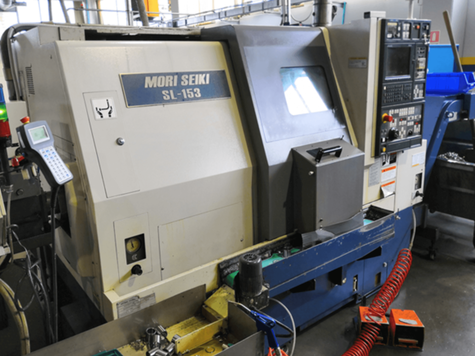 Torneiro horizontal MORI SEIKI SL-153 SMC, vista frontal, mostrando o painel de controlo e as caraterísticas de funcionamento.