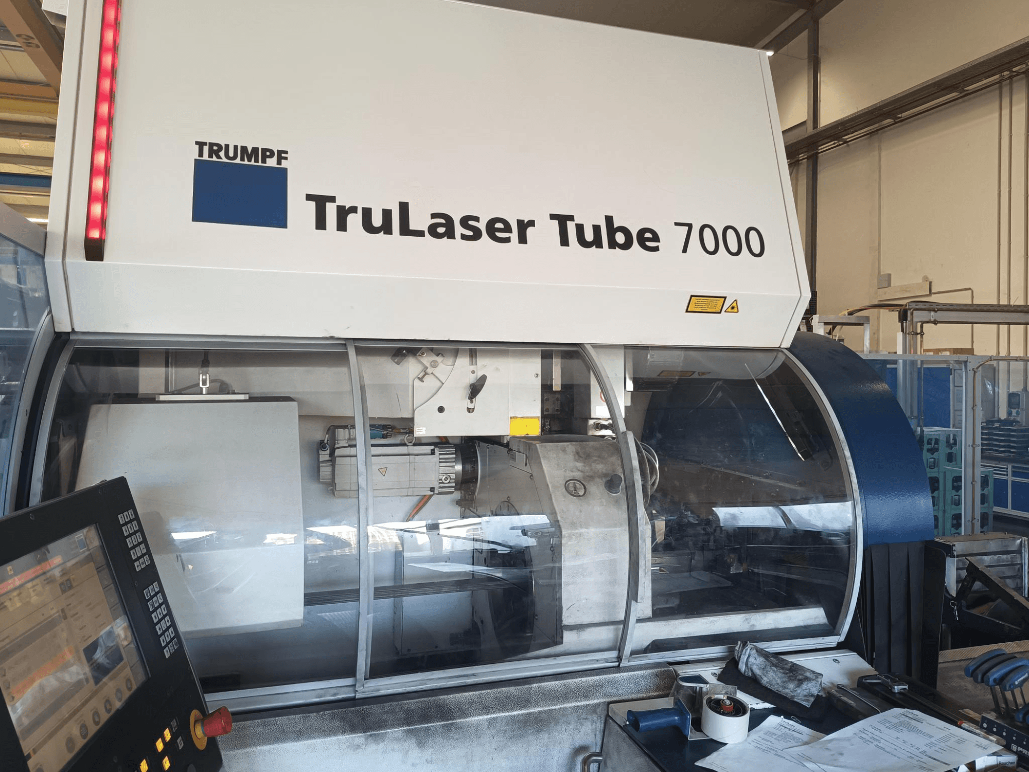 TRUMPF TruLaser Tube 7000, vista frontal da máquina com painel de controlo, apresentando as caraterísticas de corte a laser e o espaço de trabalho.