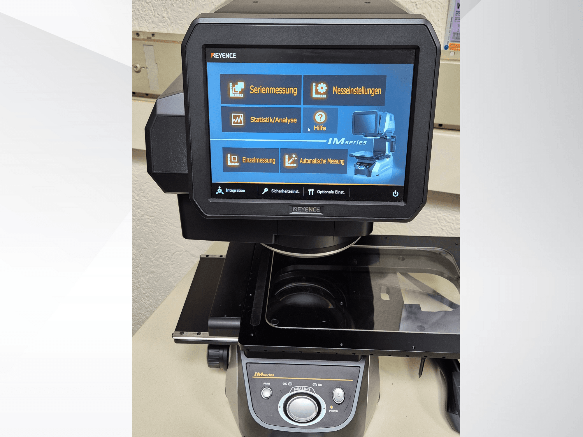 Vista frontal do dispositivo de medição da série KEYENCE IM com ecrã tátil que apresenta as opções de medição e os controlos.