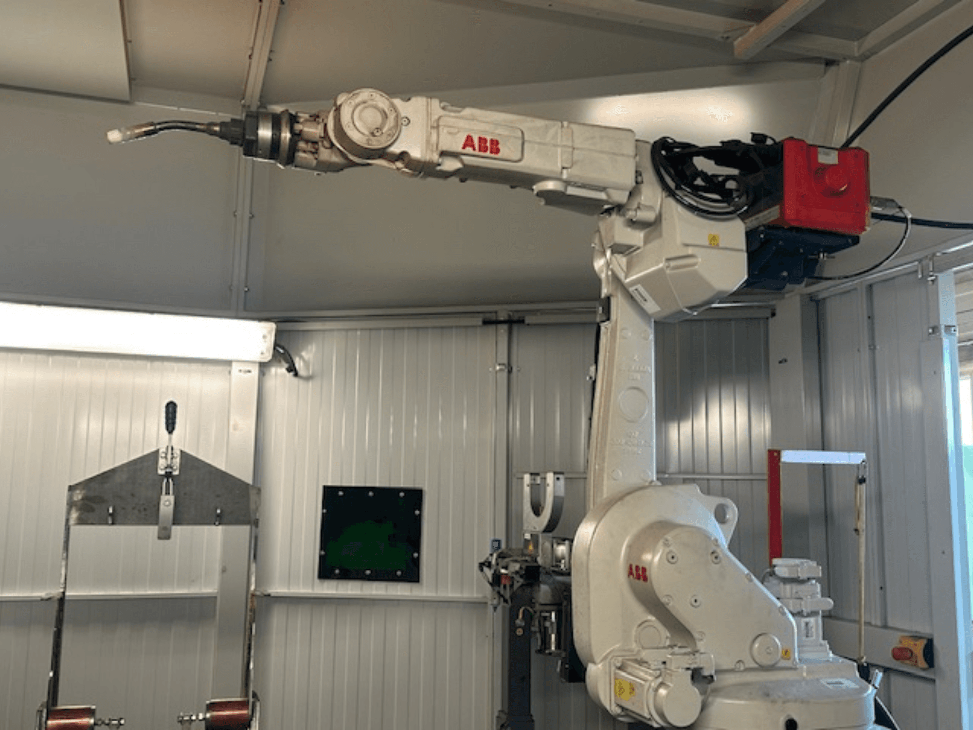 ABB Schweißroboter Flex Arc - vista lateral do braço robótico com ferramenta de soldadura, mostrando detalhes como o painel de controlo e os cabos.