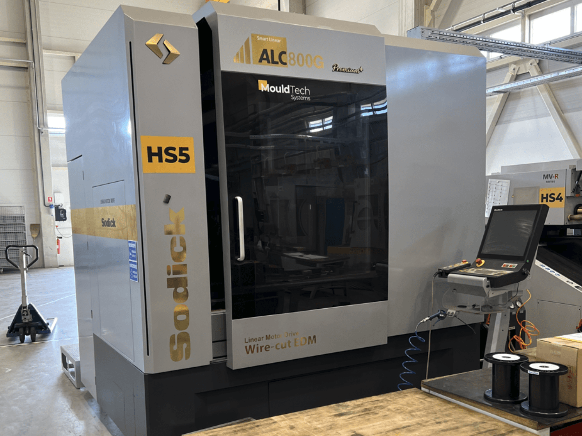 Sodick ALC800G Premium Wire EDM Machine, vista frontal, mostrando o painel de controlo e detalhes de design intrincados.
