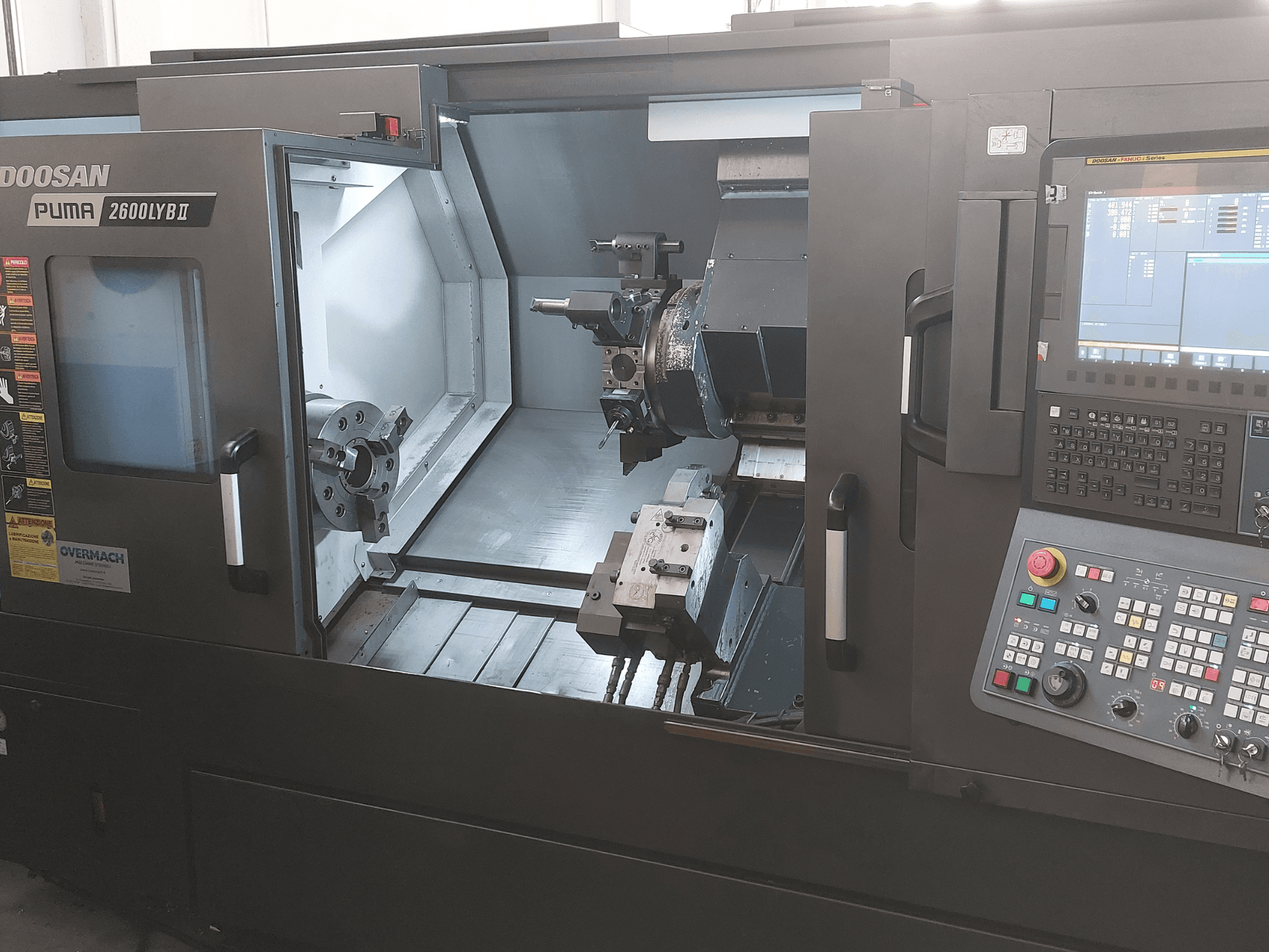 DOOSAN Puma 2600 LYB II Horizontal Turning Machine em vista frontal, mostrando o interior com mandril, suporte de ferramentas e painel de controlo.