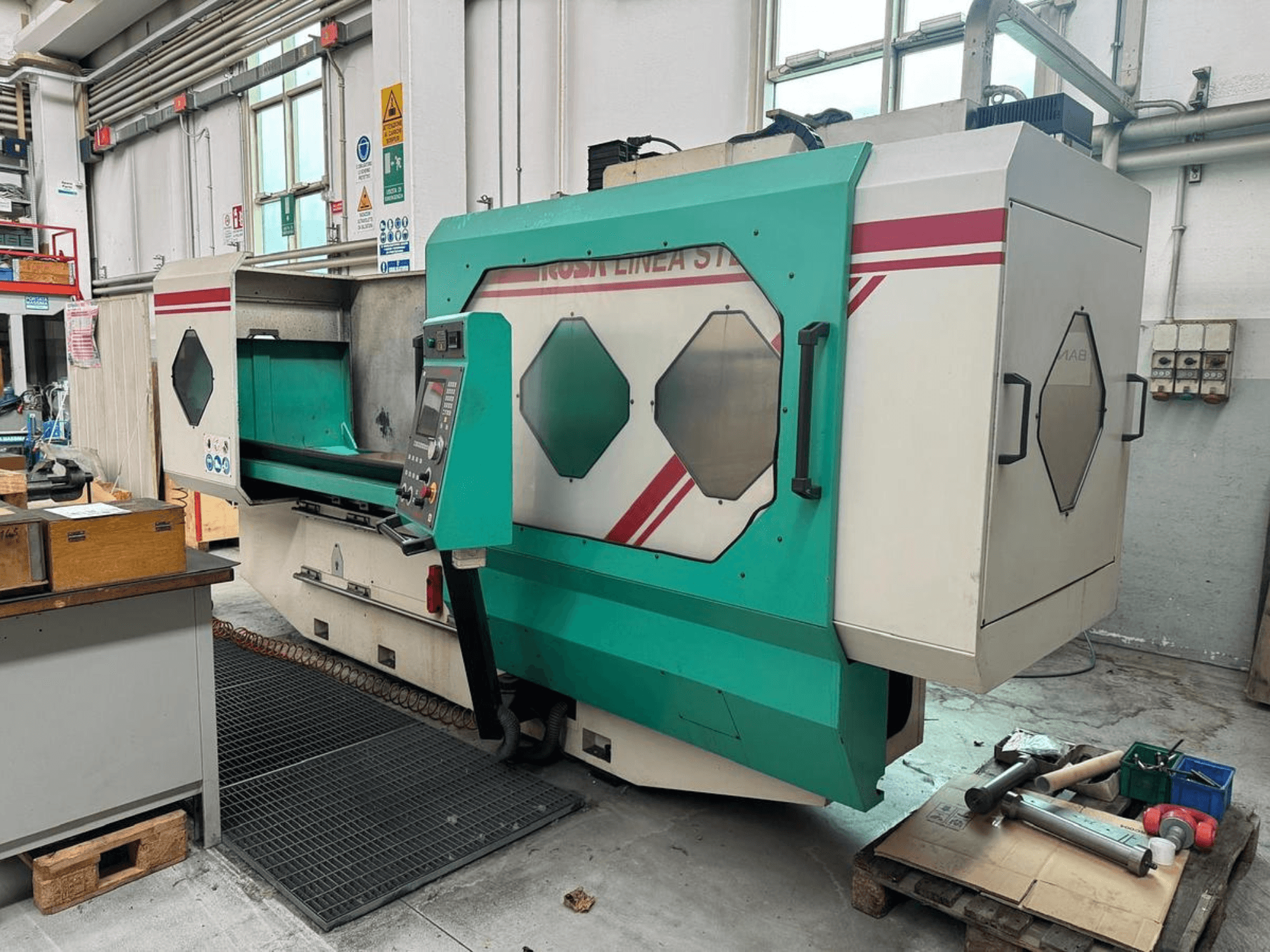 Máquina de precisão verde e branca, vista frontal, com painel de controlo, área de trabalho e ferramentas numa palete. Marca: BAMB.