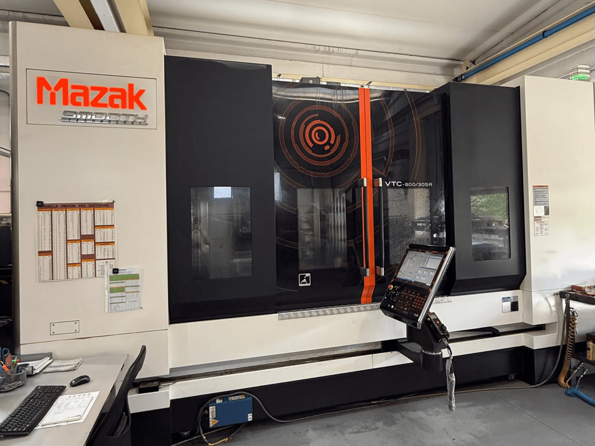 Centro de maquinagem vertical Mazak VTC-800/30SR, vista frontal que mostra o painel de controlo, o ecrã e a área de trabalho.