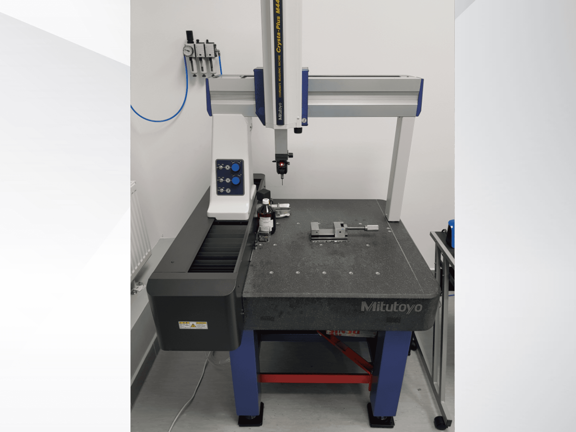 Máquina de medição por coordenadas (CMM) Mitutoyo Crysta-Plus M443, vista de frente, com sonda de medição, painel de controlo e mesa de inspeção com acessórios de fixação.