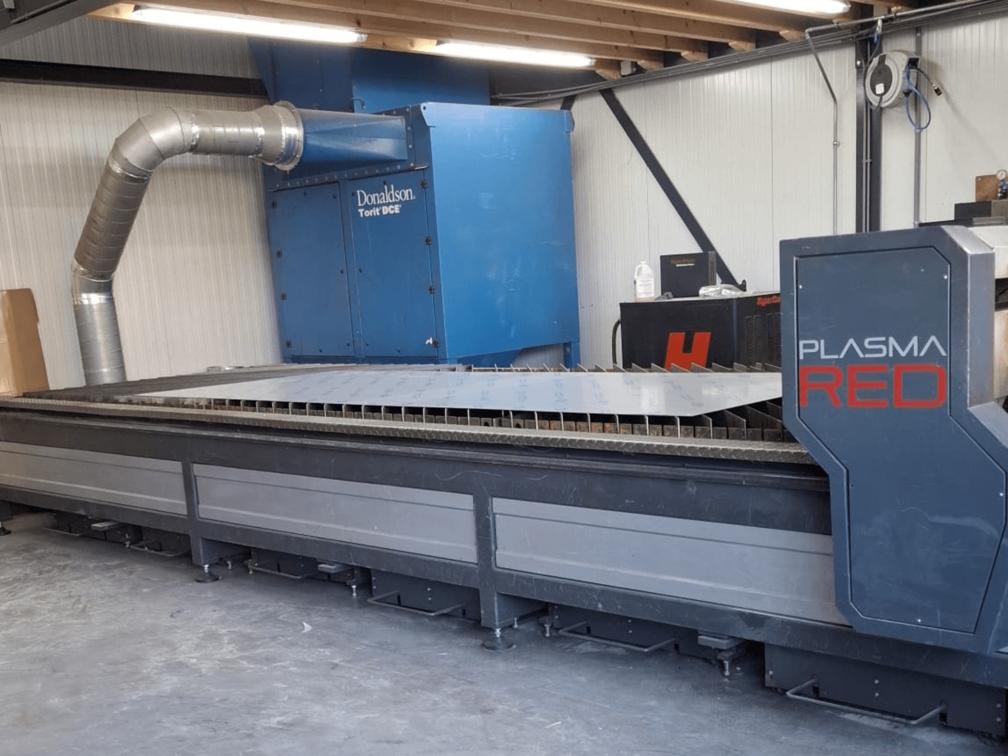 Máquina de corte a plasma SOITAAB Plasmatech-Red em vista frontal, com uma ampla mesa de corte e sistema de exaustão.