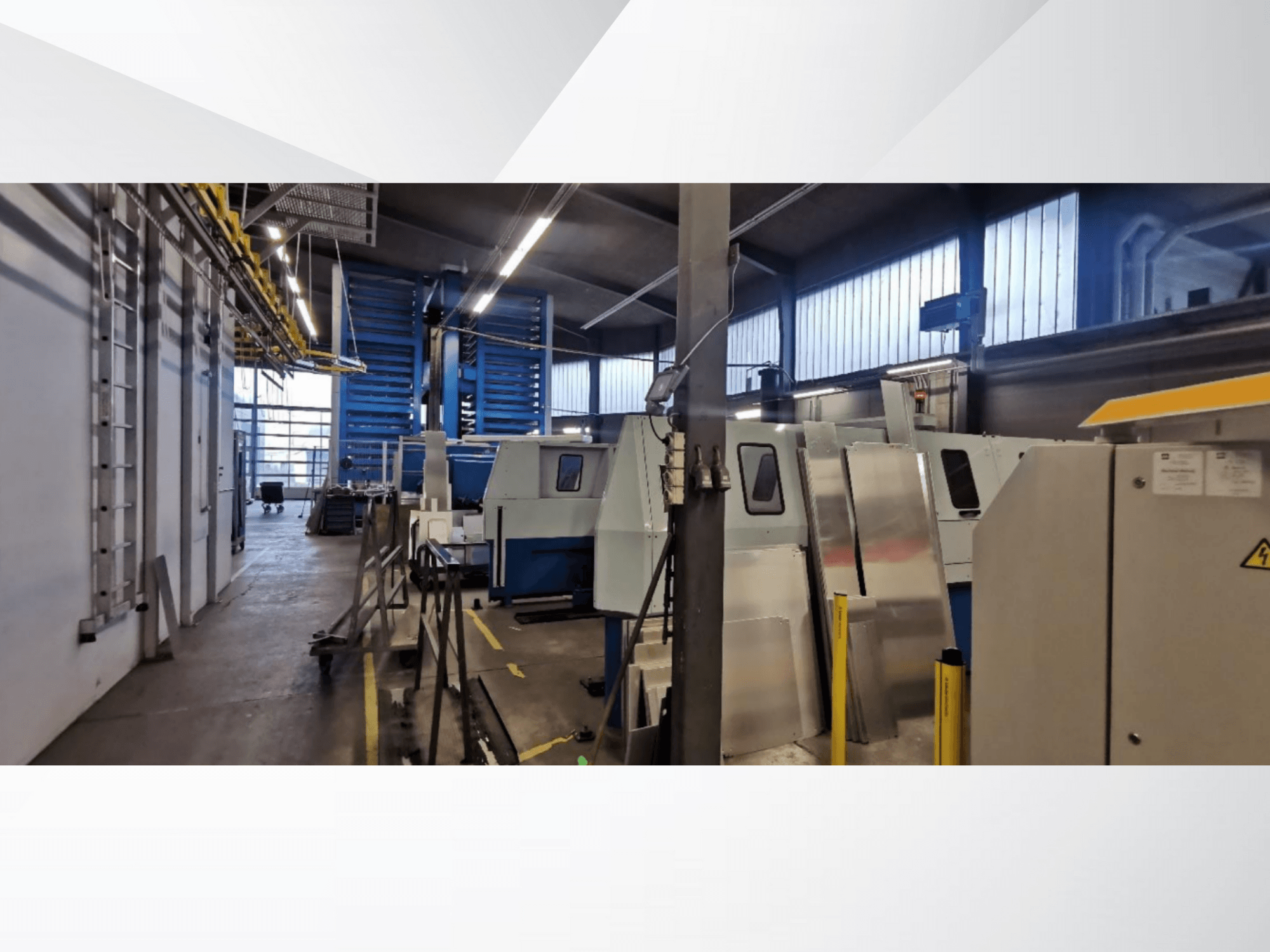 Cena de oficina industrial com várias máquinas e equipamentos numa vista lateral, com superfícies metálicas e dispositivos de segurança visíveis.