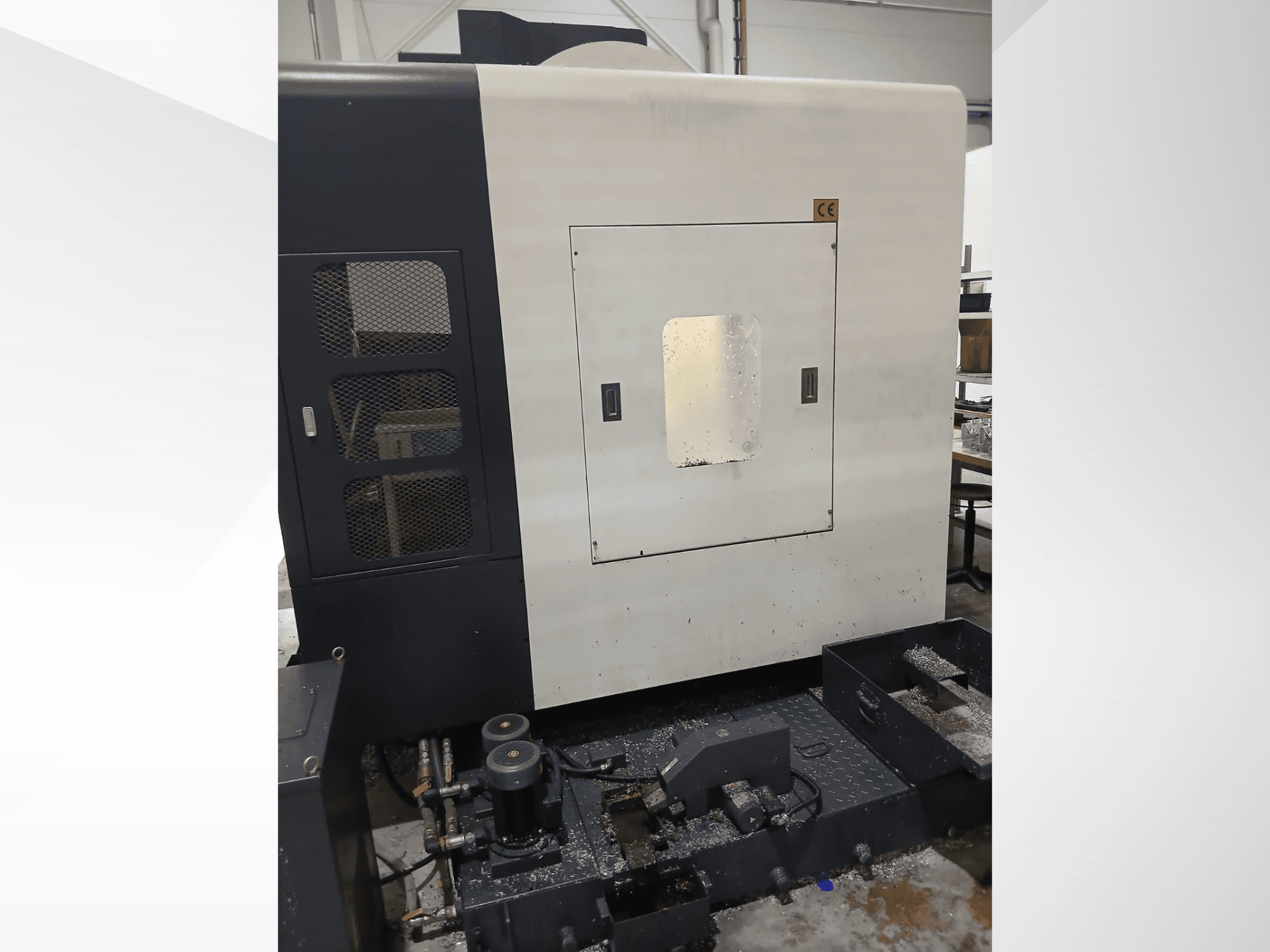 Centro de maquinagem vertical POSmill C 800 Kompakt, vista frontal que mostra o painel de controlo, o sistema de refrigeração e as limalhas de metal.