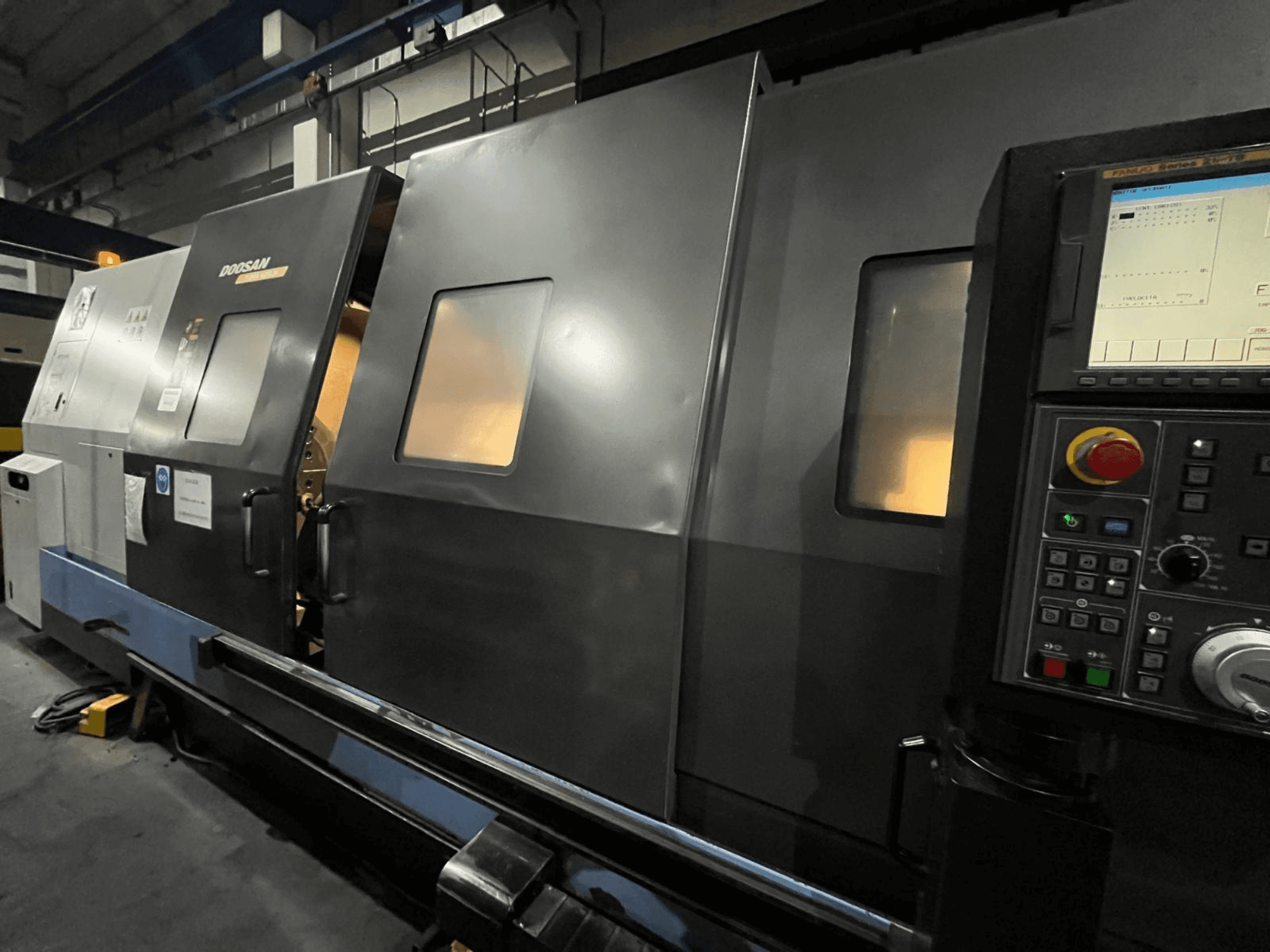 Máquina de torno CNC da Doosan em vista frontal, com painel de controlo e interface de operador com visor digital e botões visíveis.