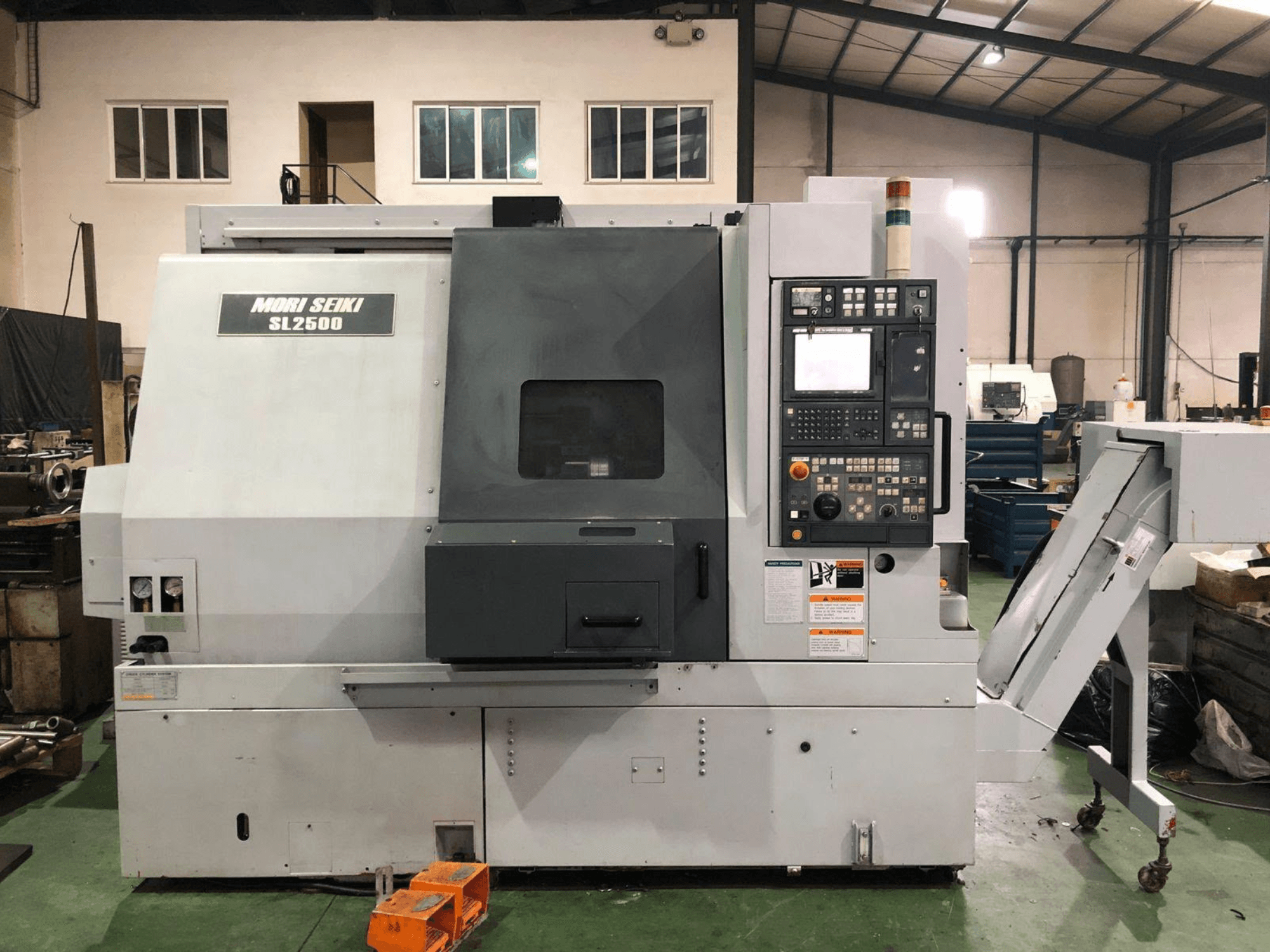 Centro de torneamento e fresagem DMG Mori Seiki SL 2500 Y, vista lateral com o painel de controlo e o transportador de aparas visíveis.