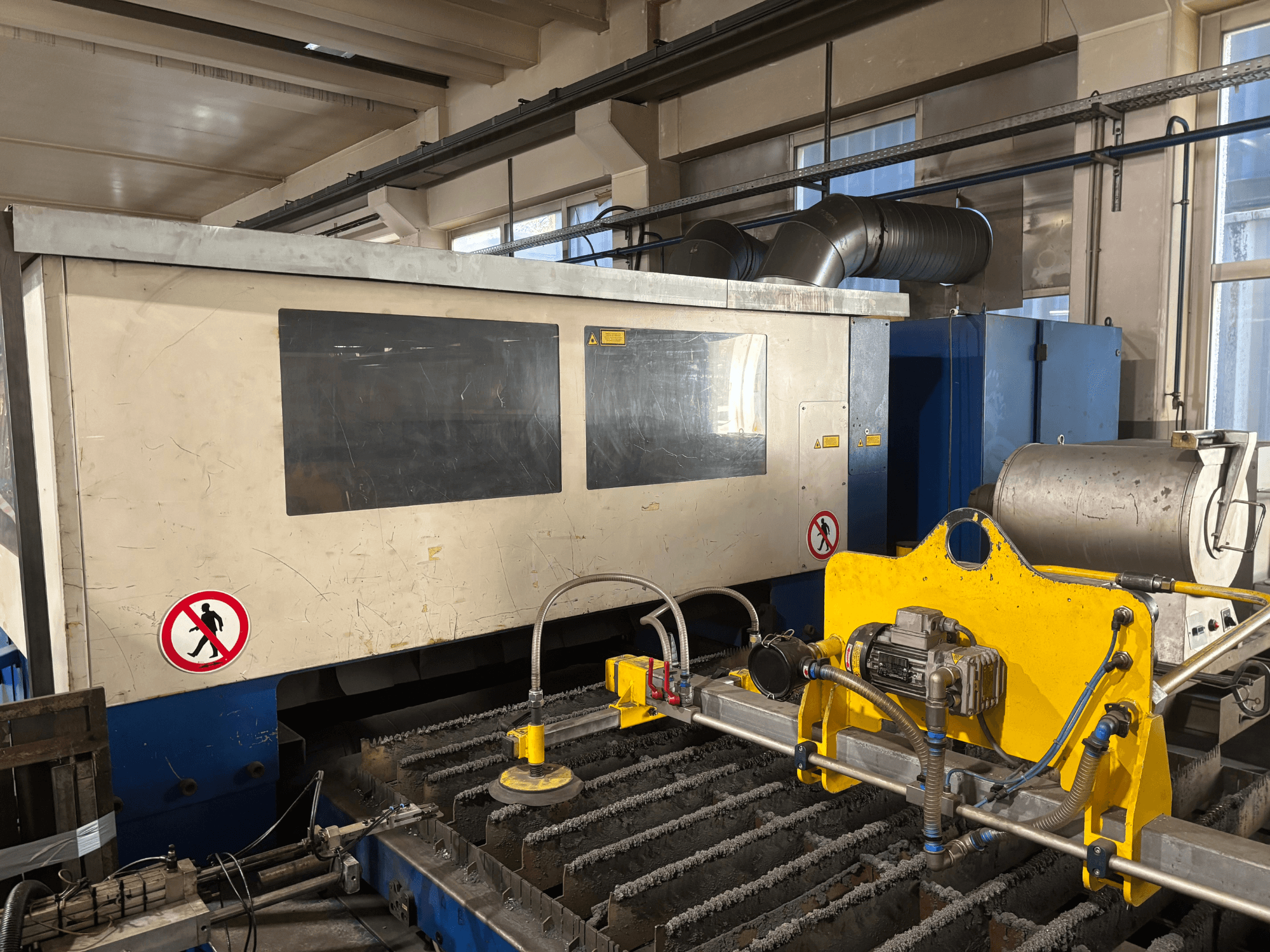 Máquina de corte a laser TRUMPF Trumatic L3030 CO2, vista frontal mostrando a interface de controlo e os detalhes da superfície de corte.