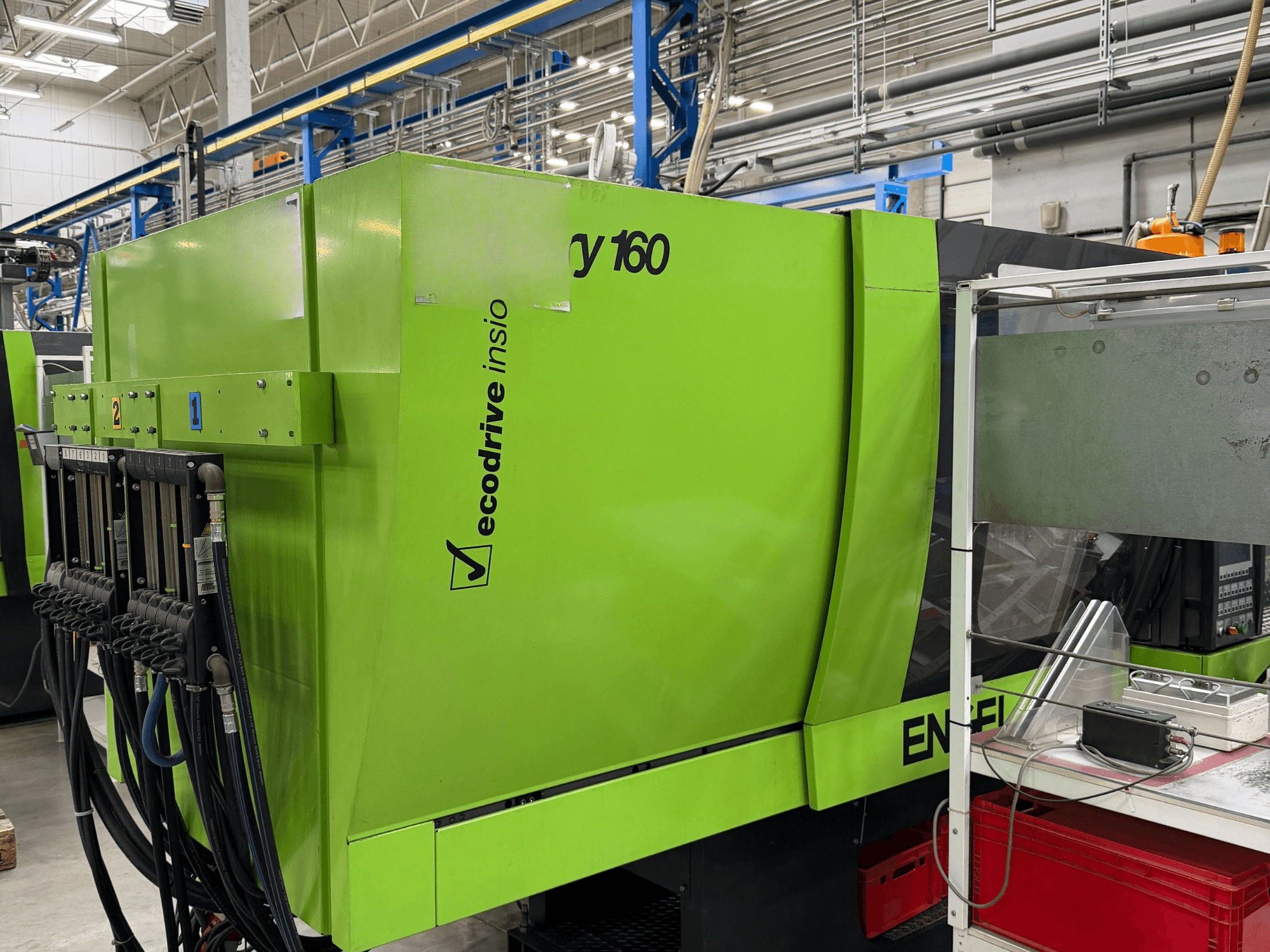 Máquina de moldagem por injeção hidráulica Engel Victory 500/160 tech, na cor verde, vista lateral que mostra o painel de controlo e a funcionalidade Ecodrive.